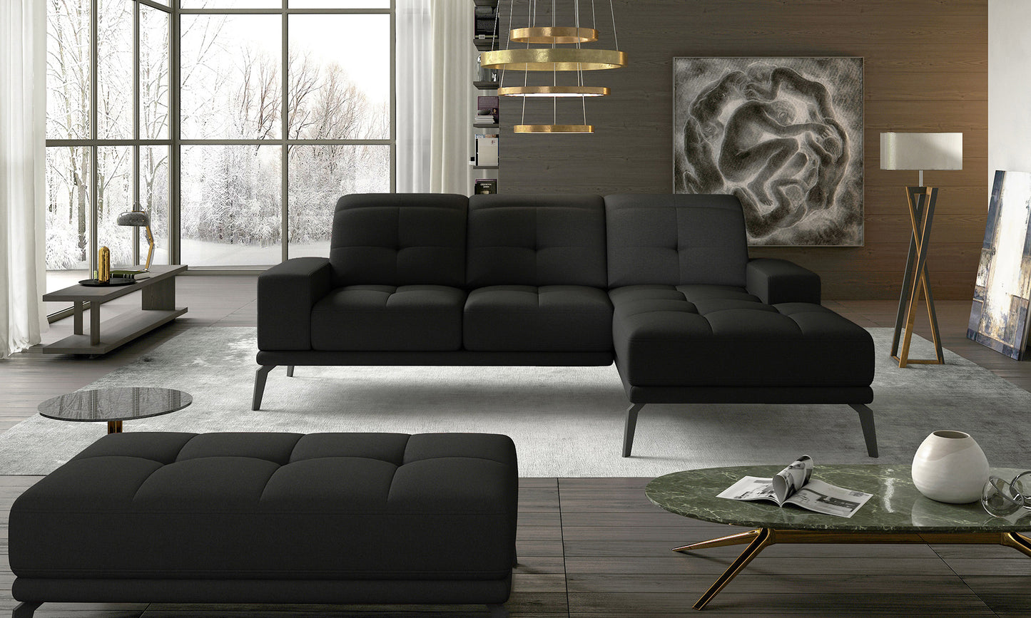 Czarny narożnik do salonu wykonany w tkaninie Sawana 14 prezentujący minimalistyczną formę oraz miękkie siedziska. Designerski narożnik prawostronny świetnie komponujący się z betonem, drewnem i nowoczesnymi dodatkami wnętrzarskimi.
