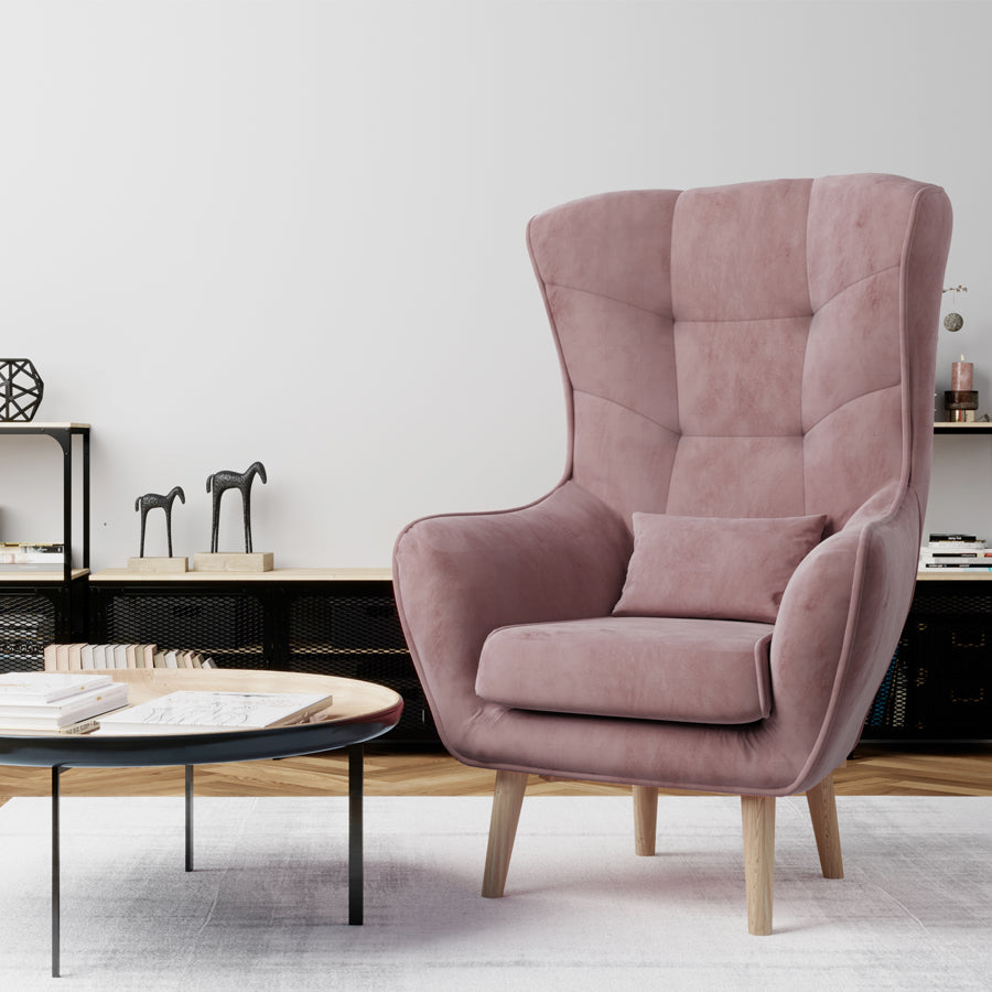 Fotel Arti w kolorze Matt Velvet 63 różowy w nowoczesnym salonie, ustawiony obok stolika kawowego na jasnym dywanie.
