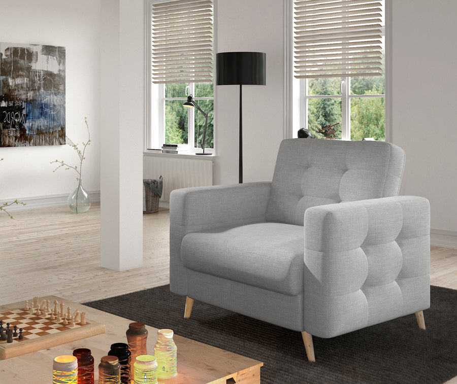 Fotel Asgard w kolorze Sawana 21 szary w eleganckim salonie, ustawiony przy stoliku kawowym na jasnej podłodze.