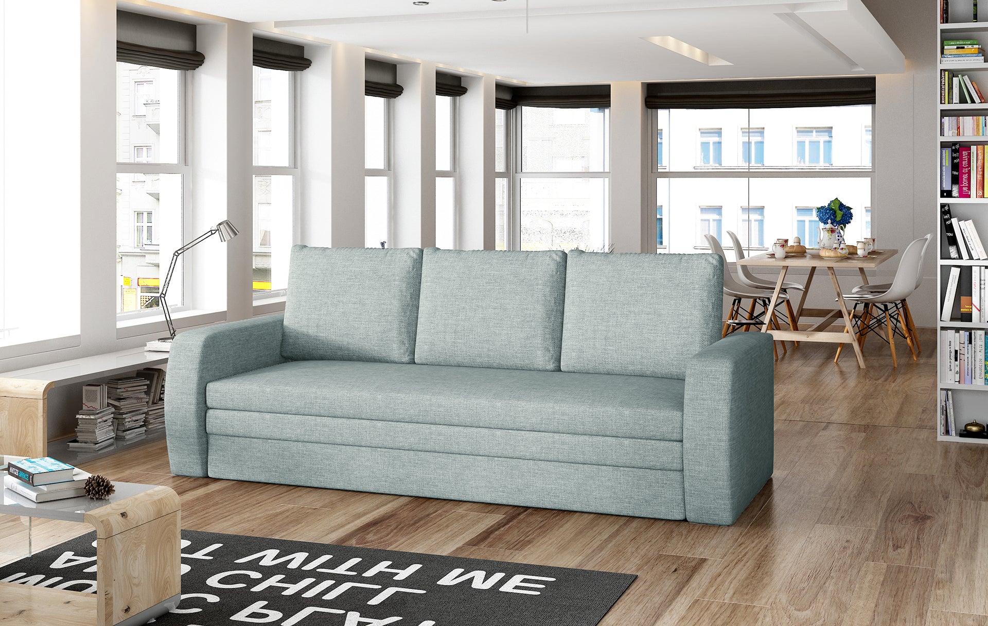 Sofa Inversa w odcieniu Cover 70 niebieski ustawiona w nowoczesnym, jasnym salonie z jadalnią w tle.