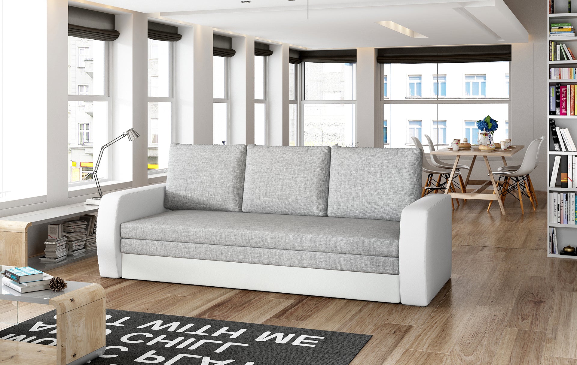 Sofa Inversa w odcieniach Sawana 21 szary i Soft 17 biały ustawiona w nowoczesnym, jasnym salonie z jadalnią w tle.