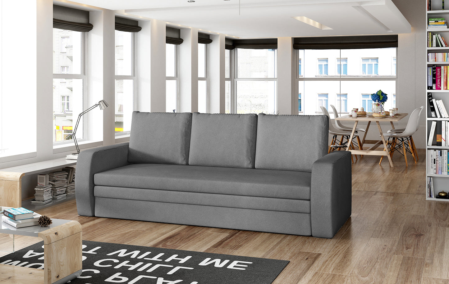 Sofa Inversa w odcieniu Soro 93 szary ustawiona w nowoczesnym, jasnym salonie z jadalnią w tle.