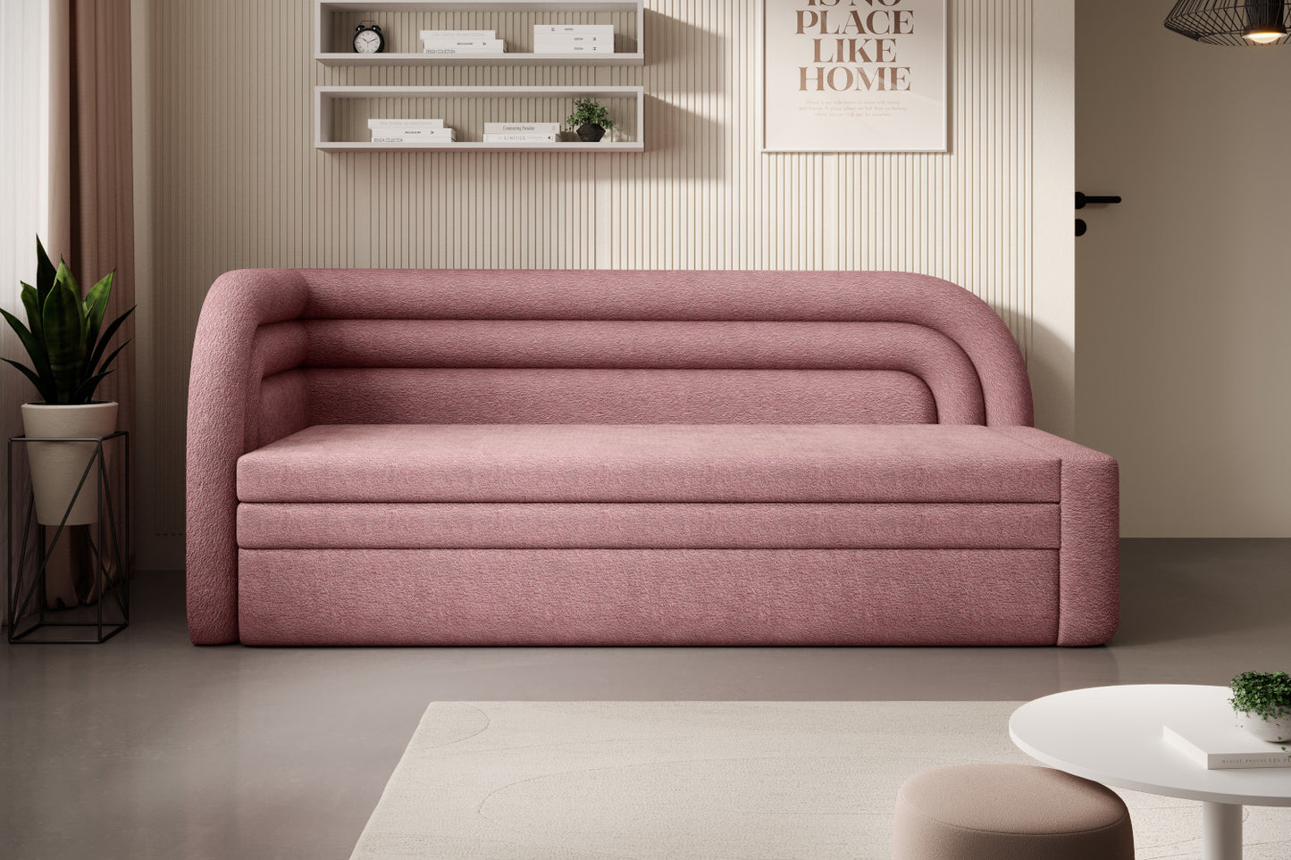 Lewostronna sofa Fabillo Touch 24 w kolorze różowym ustawiona w przytulnym salonie, na tle żeberkowanej, kremowej ściany z półkami i zieloną rośliną.