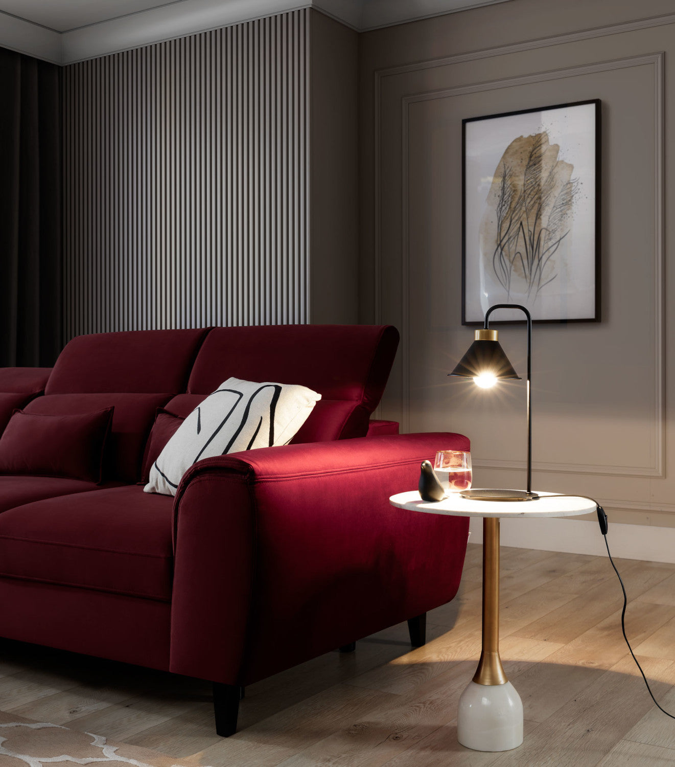 Aranżacja salonu po zmroku – czarna lampa Detmer włączona na stoliku przy sofie, tworząca ciepłe, punktowe oświetlenie ściany.