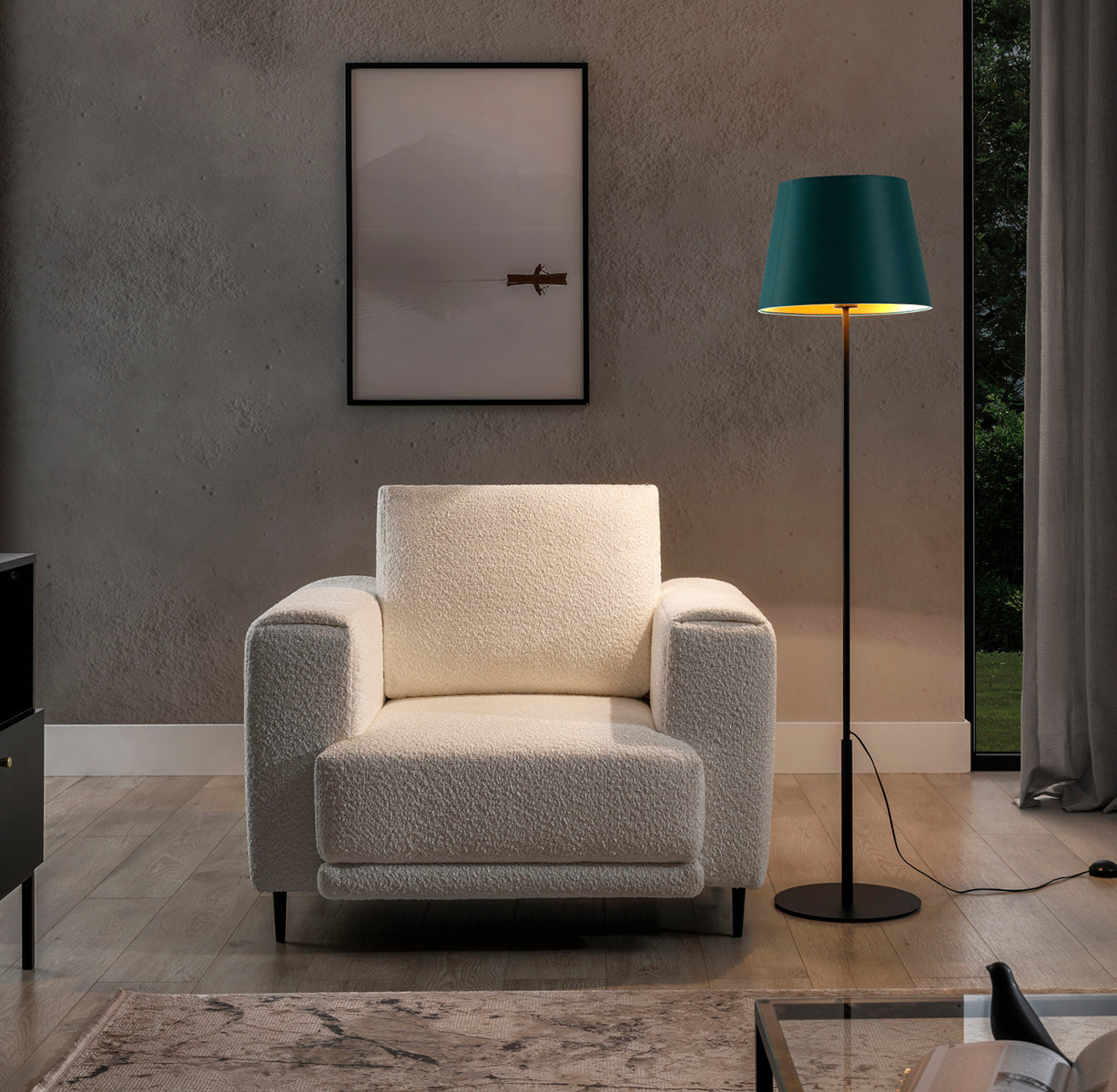 Włączona lampa stojąca Vespillo 1a z zielonym abażurem i złotym wnętrzem, emitująca ciepłe światło na fotel i ścianę, tworząc przytulny nastrój wieczorem.
