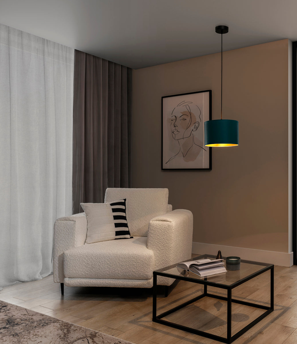 Włączona lampa wisząca Vespillo rzucająca ciepłe, złote światło na fotel i strefę wypoczynkową w przytulnej, wieczornej aranżacji salonu.