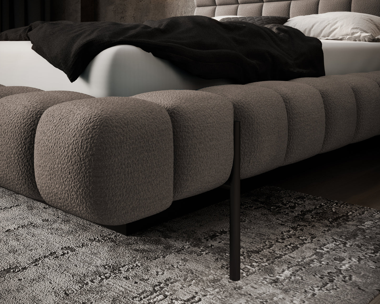 Zbliżenie na narożnik łóżka Magentta w tkaninie Amore 20 jasnobrązowy, z miękkim pikowaniem i metalową nogą w eleganckiej sypialni.