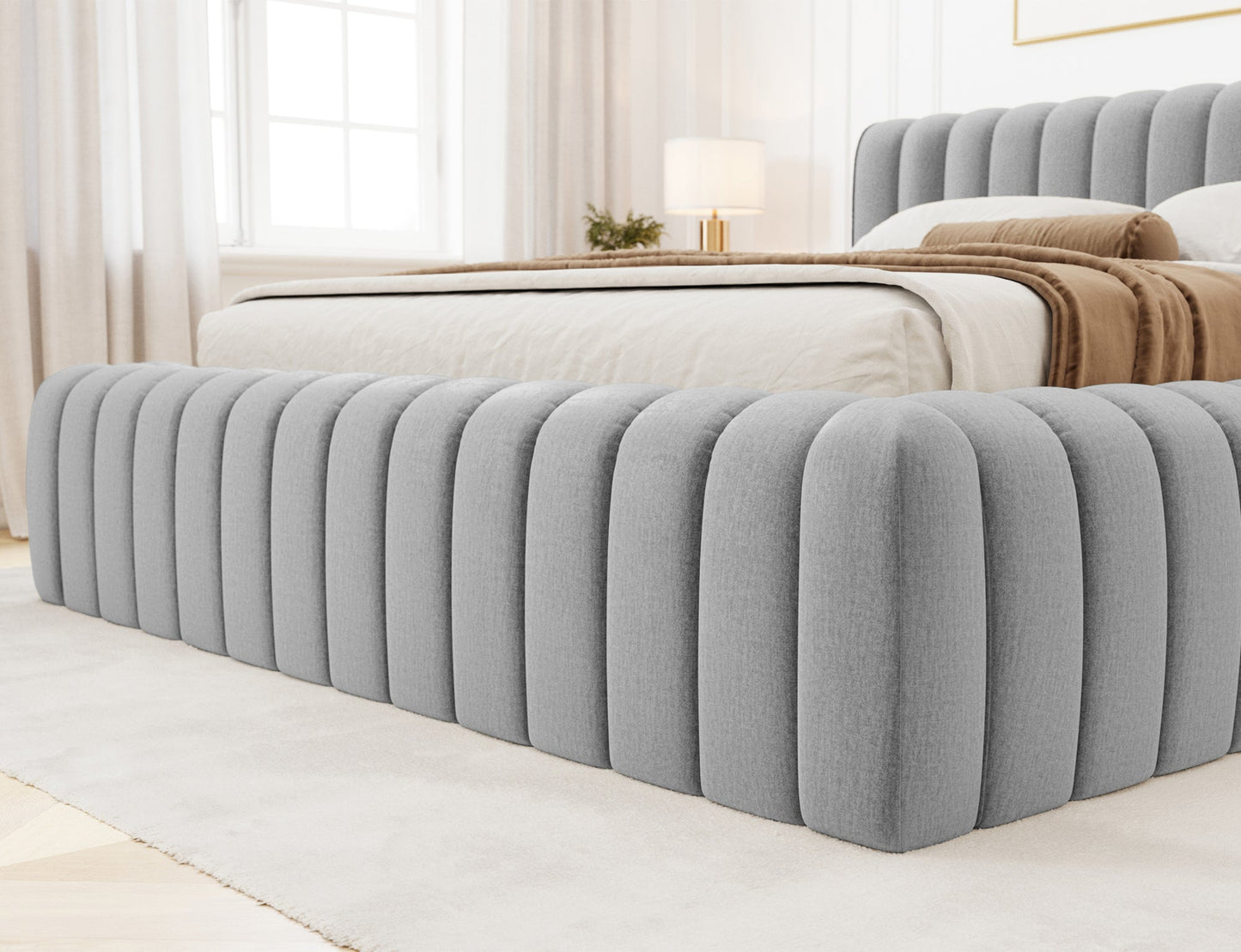 Detal frontu łóżka Carilla Monolith 85 szary z pionowym pikowaniem i miękkim obiciem w eleganckiej sypialni.