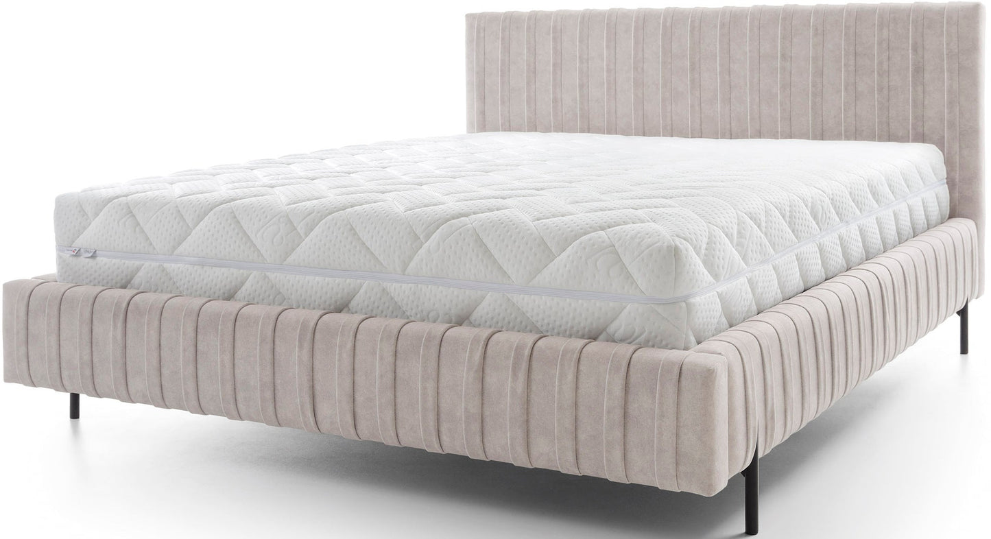 Frontowy widok łóżka Plissa 160×200 w tkaninie Relax 18 beżowy na białym tle, z pikowanym wezgłowiem i smukłymi czarnymi nogami.