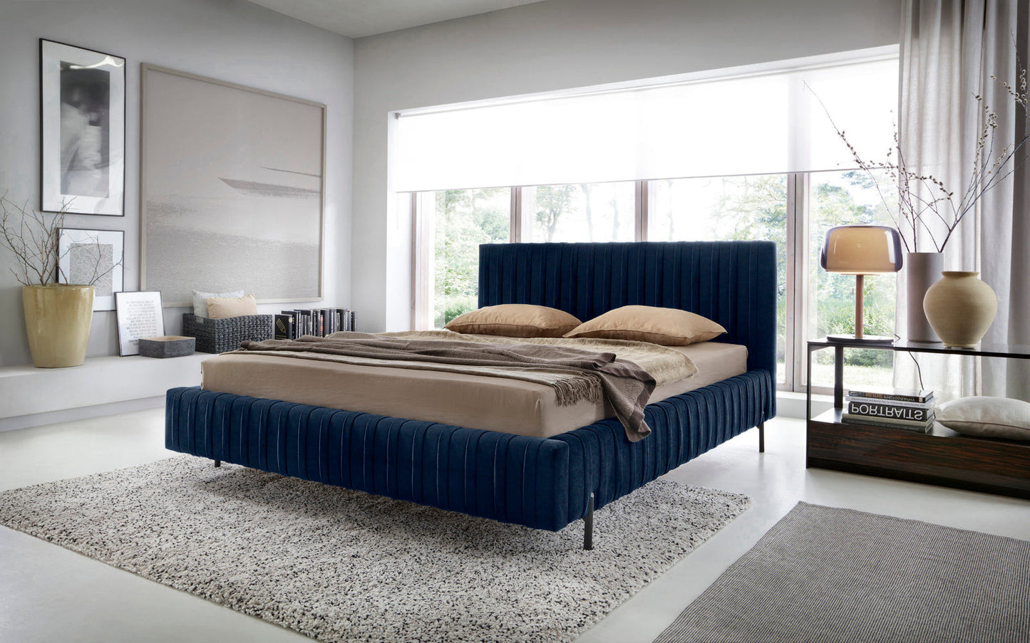 Łóżko Plissa 140×200 Velvetmat 40 granatowe w stylowej sypialni z dużym oknem, udekorowane beżową pościelą, narzutą i designerską lampką na szklanym stoliku.