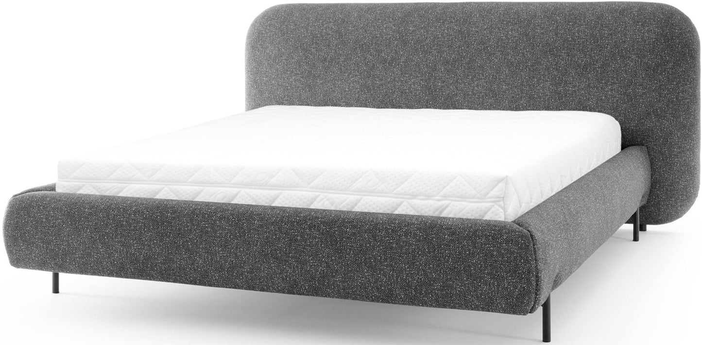 Minimalistyczne łóżko Pointt w tkaninie Breona 04 (szary) zachwyca nowoczesną formą i subtelną, miękką linią wezgłowia.