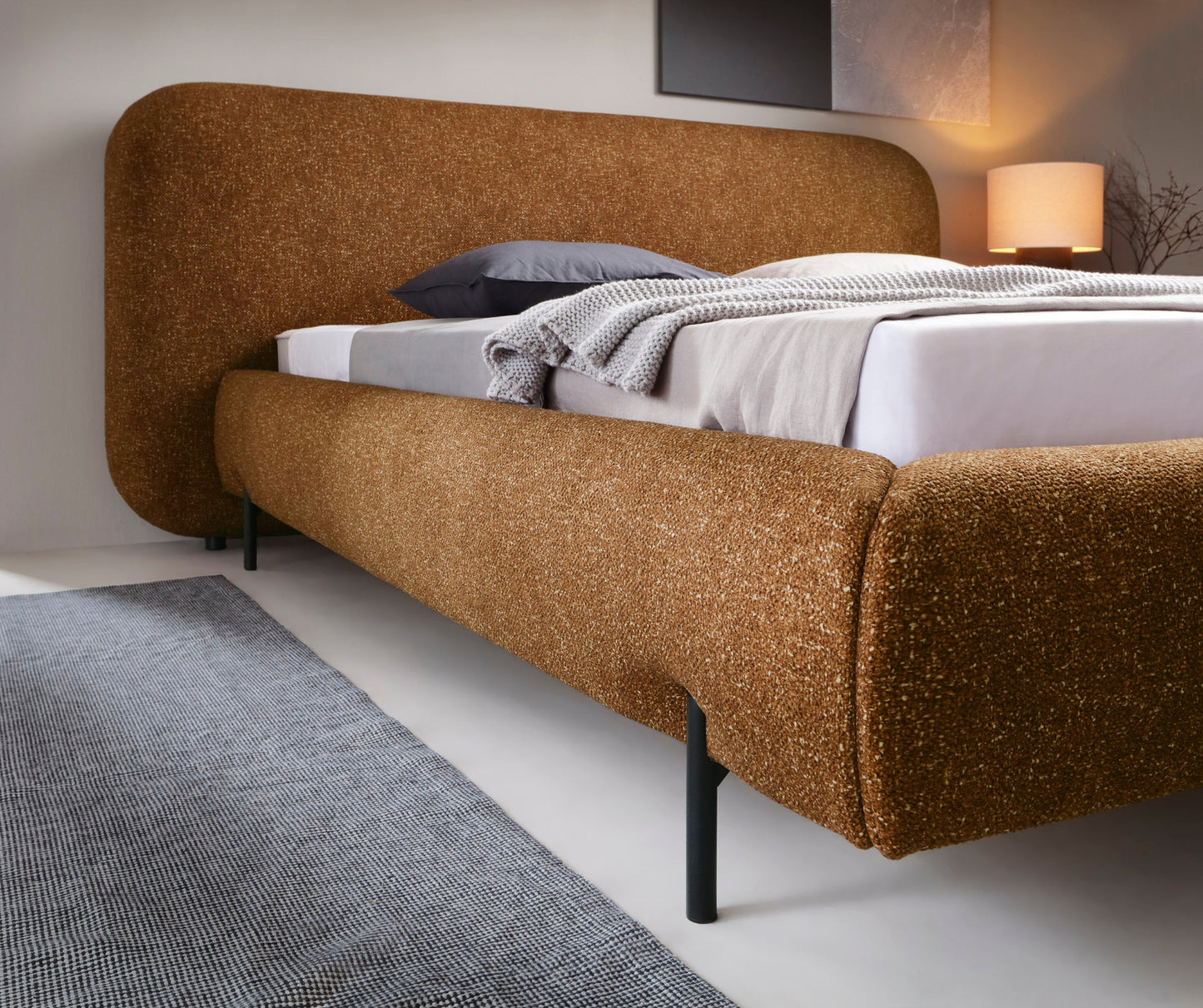 Detal korpusu łóżka Pointt w tkaninie Breona 45 żółty – zaokrąglony kształt, eleganckie wykończenie i solidna konstrukcja na metalowych nogach.