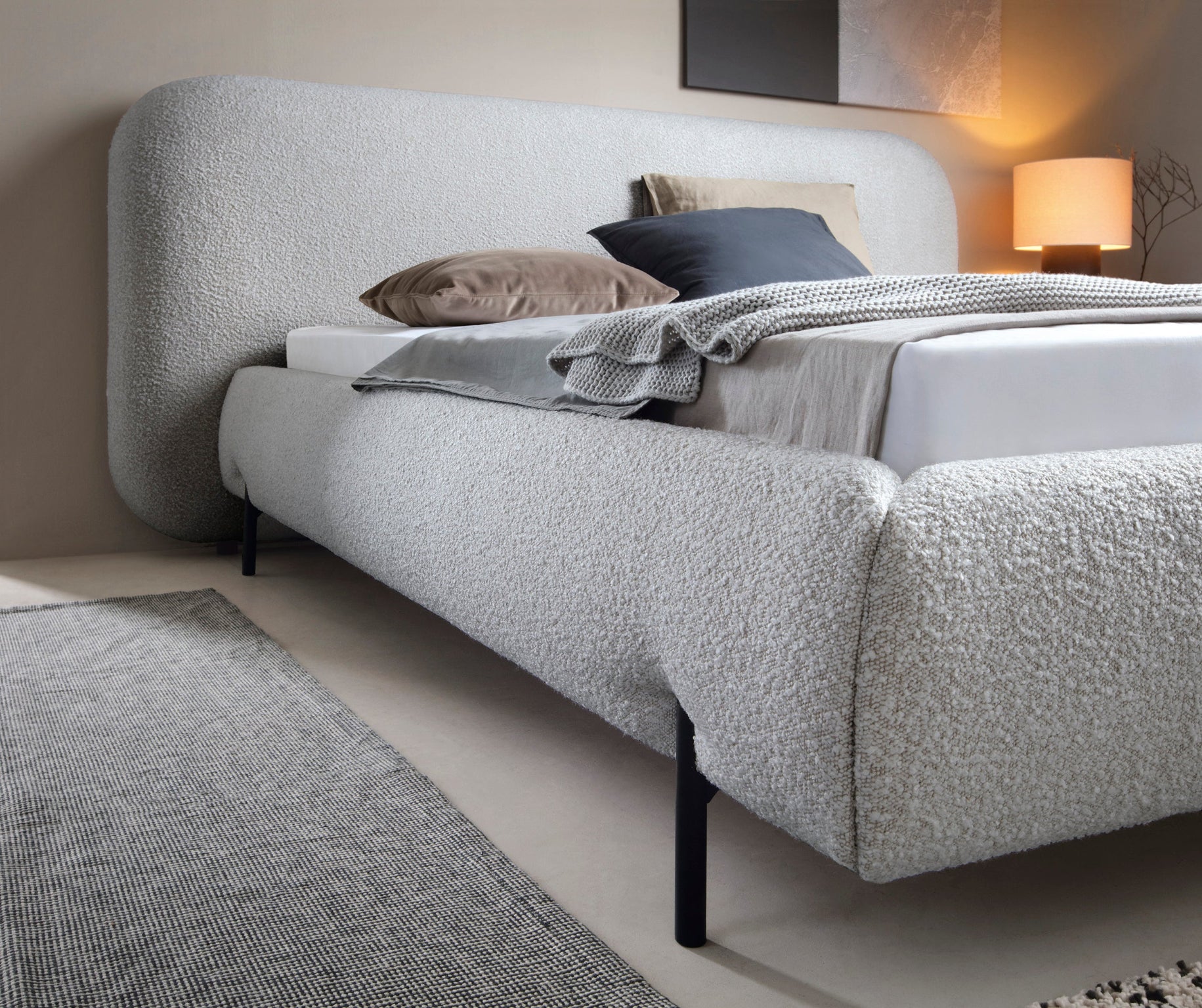 Zaokrąglony korpus łóżka Pointt Jaffray 03 w tkaninie boucle – elegancka forma i jasnoszary odcień do nowoczesnych wnętrz sypialnianych.