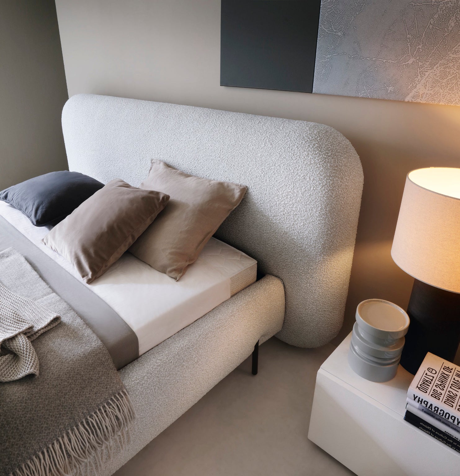 Miękki i zaokrąglony zagłówek łóżka Pointt Jaffray 03 w tkaninie boucle – komfortowy i nowoczesny akcent w szarej sypialni.
