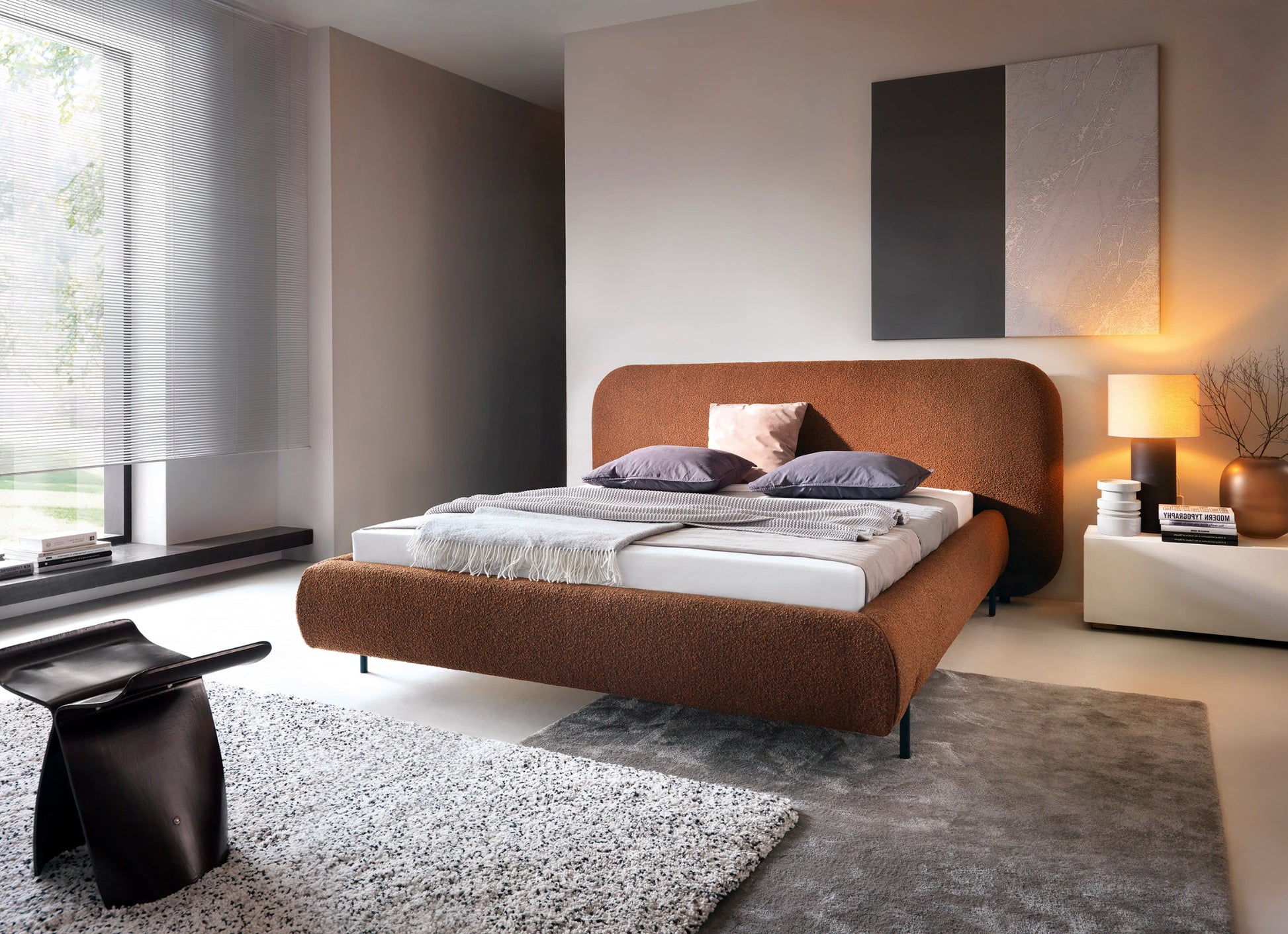 Nowoczesne łóżko Pointt Jaffray 30 w kolorze ceglastym z tkaniny boucle w aranżacji sypialni – stylowy design i komfortowe wykończenie.