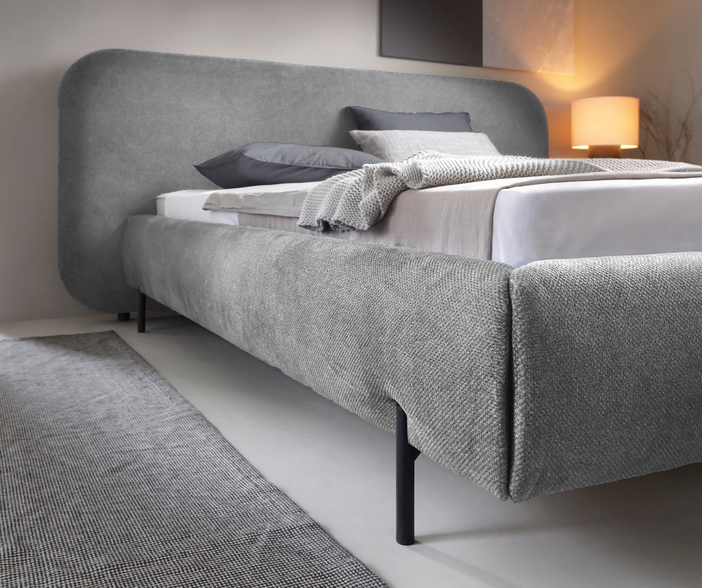 Korpus łóżka Pointt Paolli 04 w szarym kolorze – solidna tapicerowana rama z metalowymi nogami do nowoczesnej sypialni.