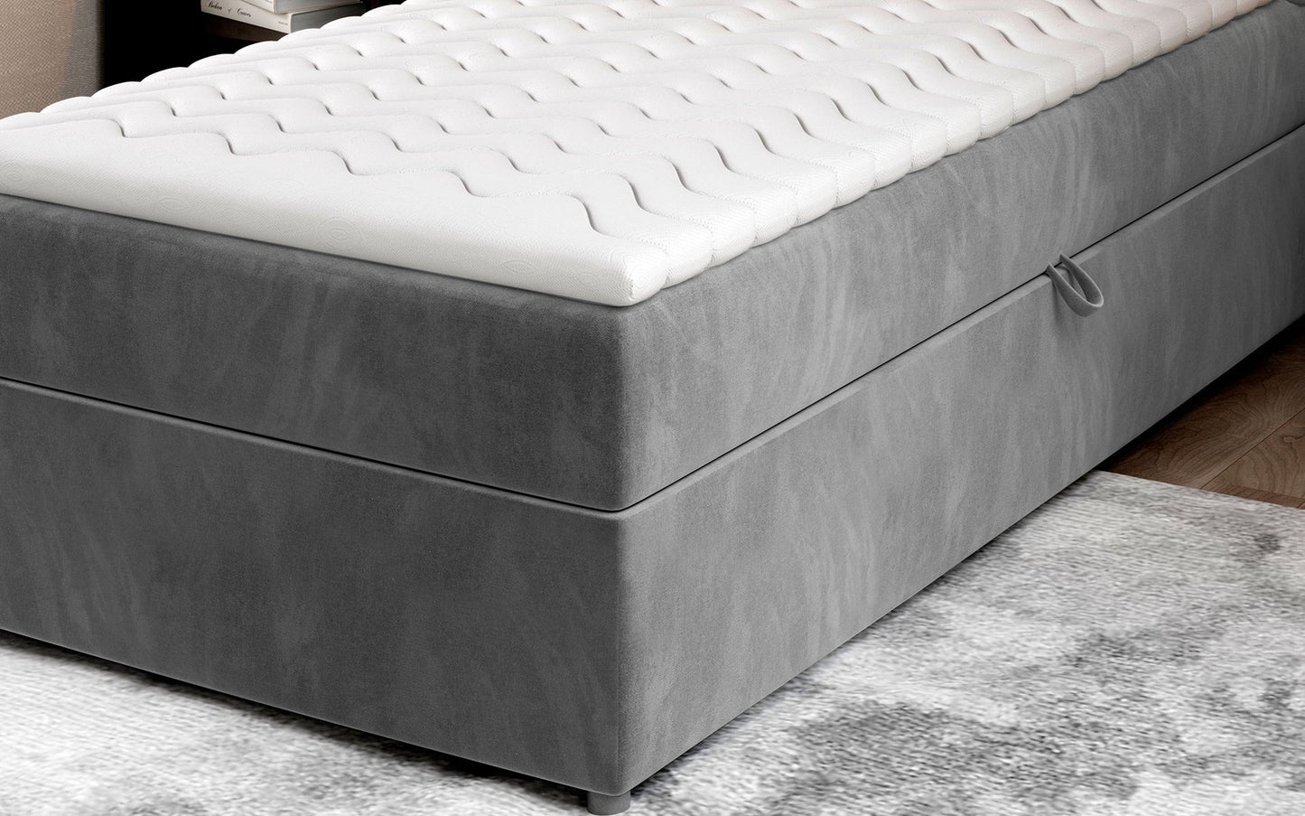 Zbliżenie na dolną część łóżka Rivia w kolorze Monolith 84 jasnoszary o wymiarach 90x200 cm, z widocznym pojemnikiem na pościel.