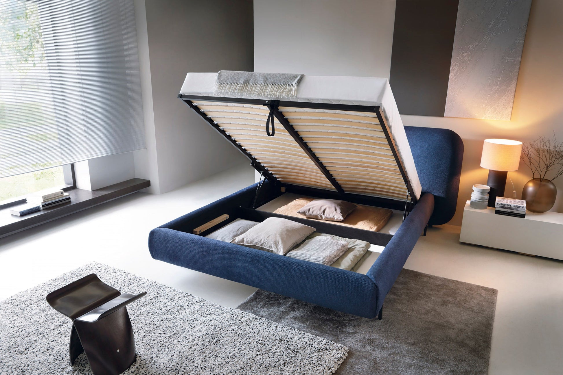 Otwarte niebieskie łóżko tapicerowane Paoli 160×200 cm z pojemną skrzynią na pościel w nowoczesnej sypialni