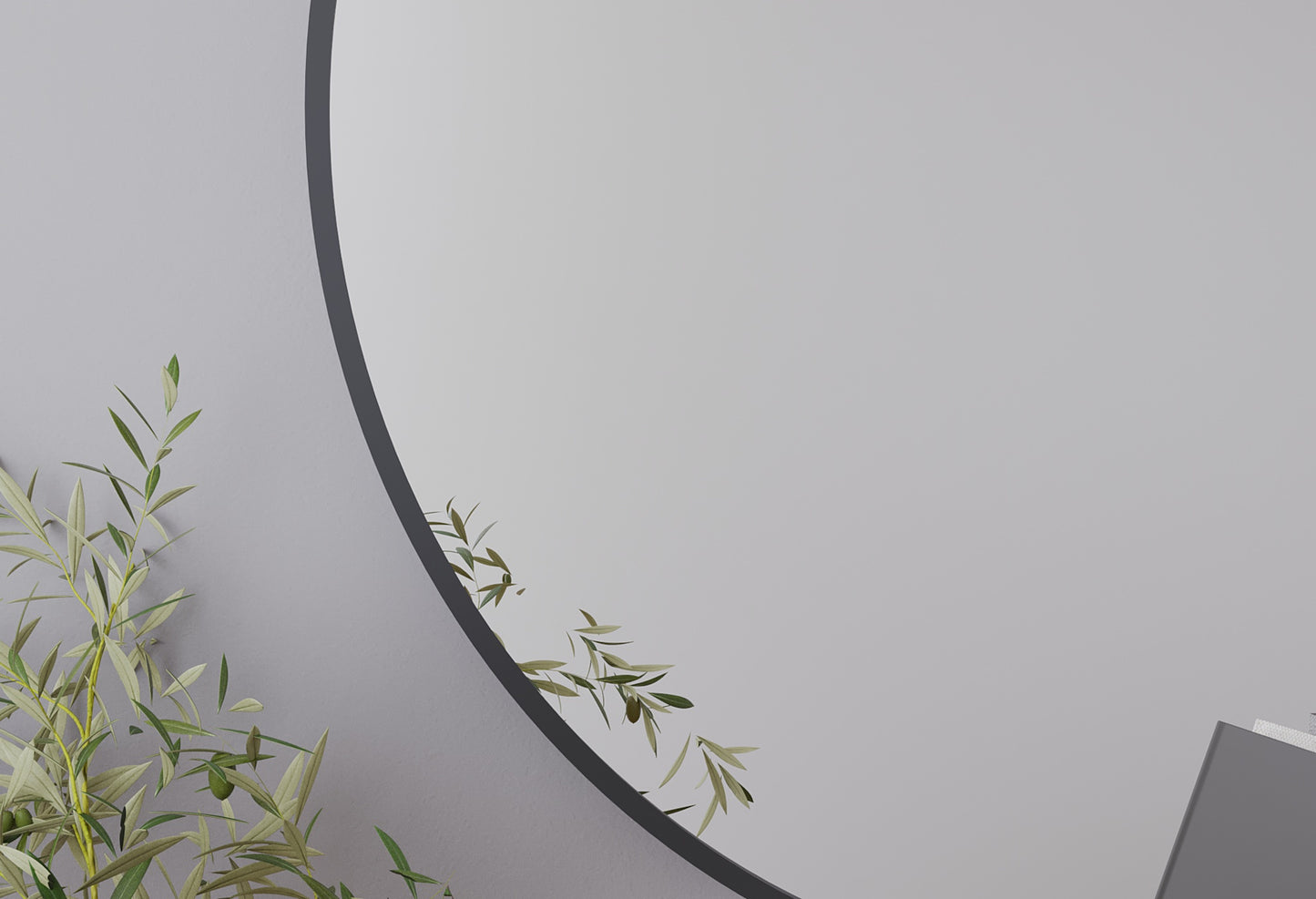 Zbliżenie na krawędź lustra Divissi 60 cm z cienką ramą, odbijające roślinę doniczkową.