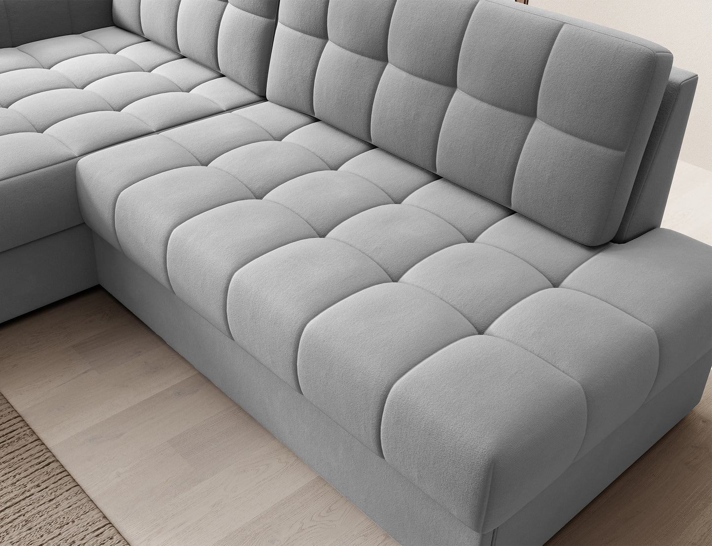 Zbliżenie na siedzisko narożnika Blezalt lewy Sola 04 jasnoszary – pikowana tapicerka i fragment oparcia widoczne z góry.