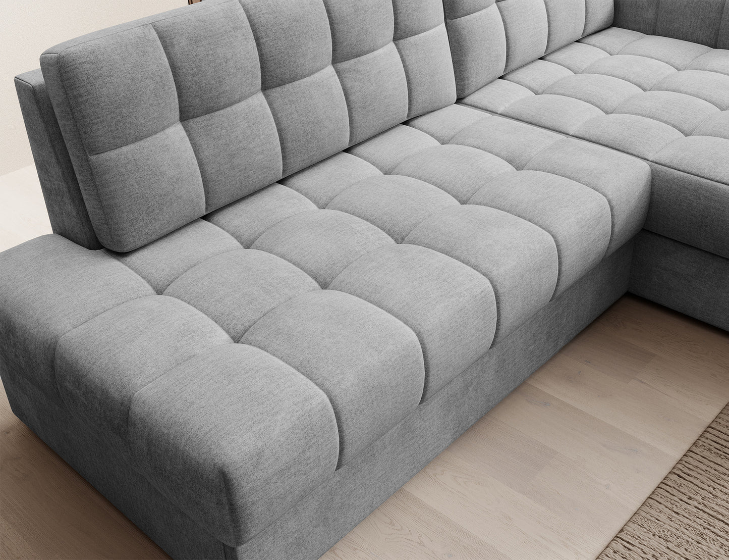 Perspektywa narożna siedziska narożnika Blezalt Monolith 85 – szara tapicerka z pikowaniem i miękką, geometryczną formą modułów.