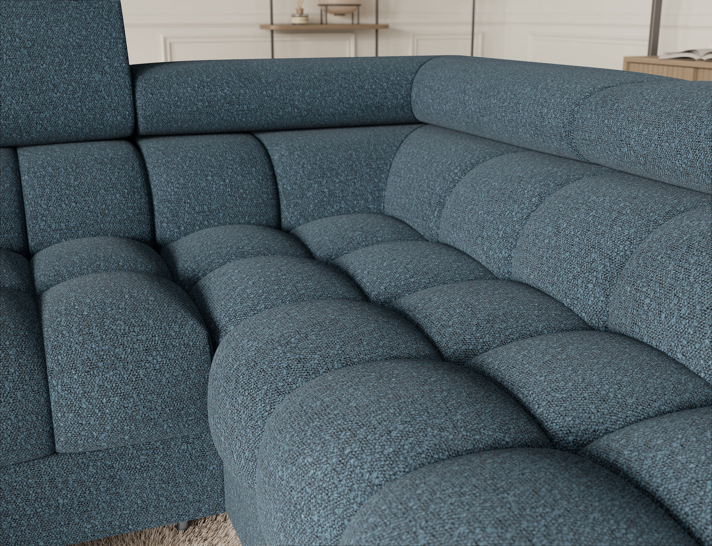 Detal narożnika Fectory w niebieskim kolorze, ukazujący teksturę materiału tapicerki oraz elegancki design z metalowymi nogami.