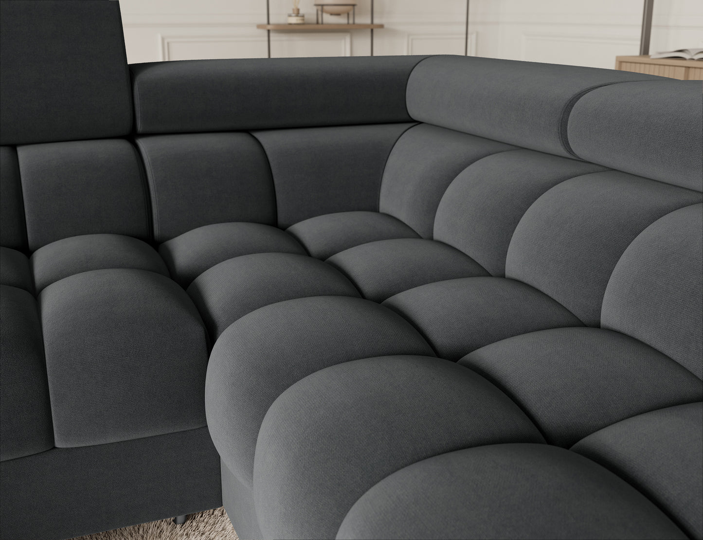 Eleganckie zbliżenie na narożnik Fectory w szarej tkaninie Sola 06, pokazujące charakterystyczne pikowanie oraz metalowe nogi, które podkreślają nowoczesny wygląd.