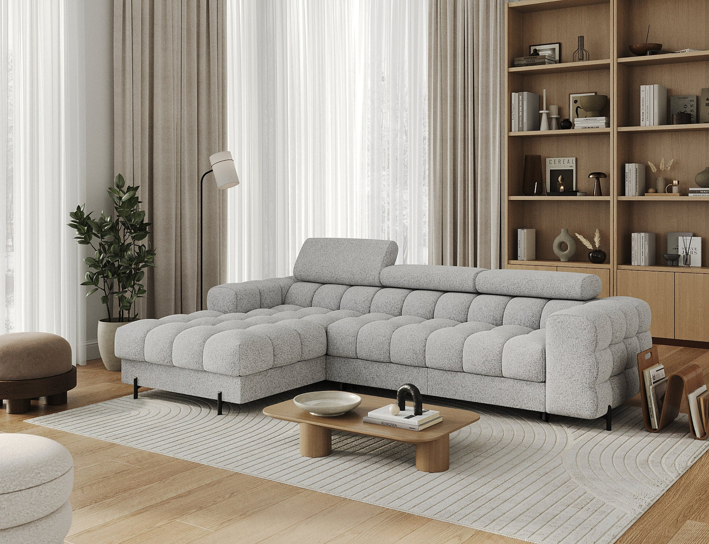 Narożnik Felro w tkaninie Pellerito 03 w jasnoszarej barwie, ustawiony w aranżacji, elegancki design z funkcją spania i pojemnikiem na pościel.