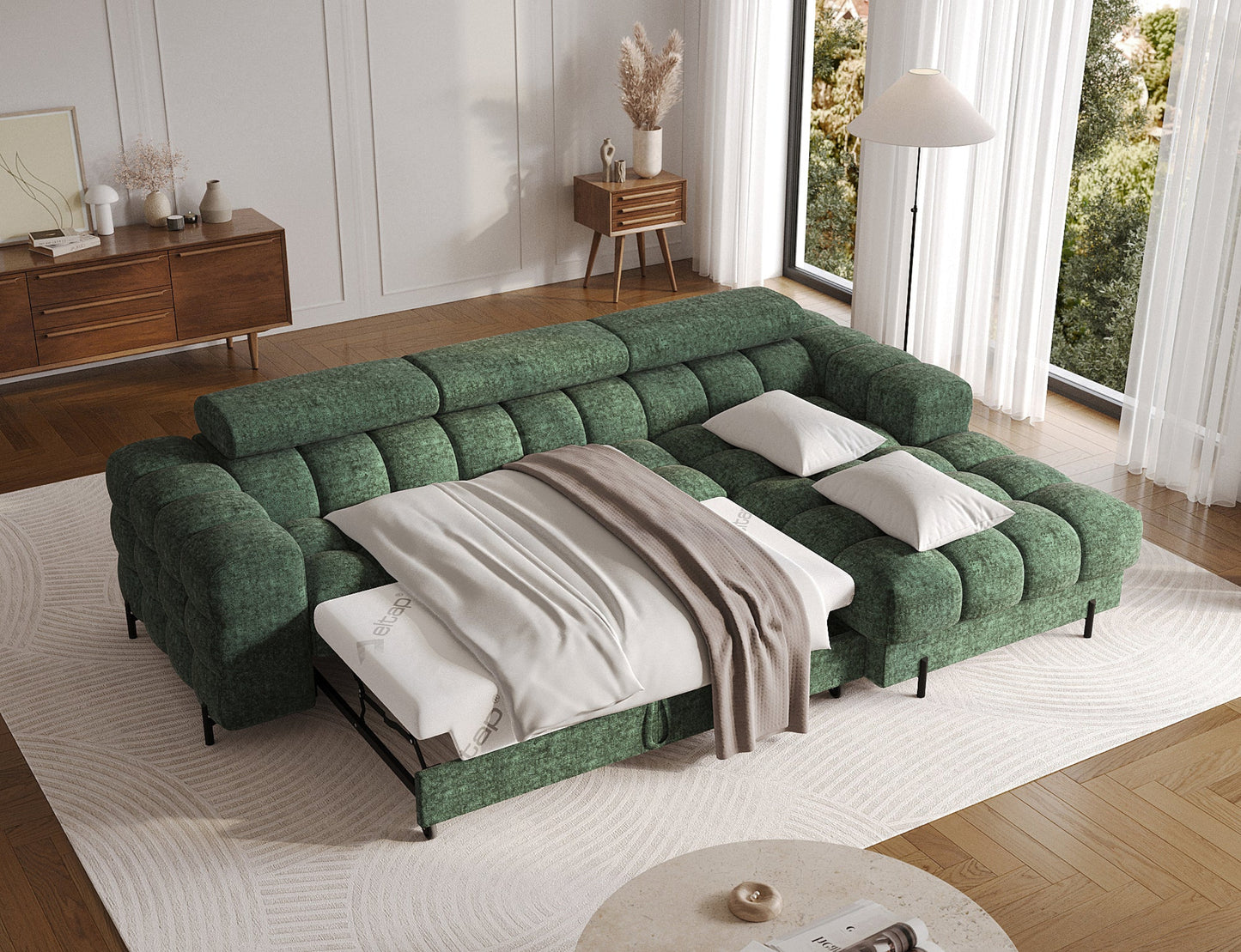 Narożna sofa zielona z funkcją spania, rozłożona, z pościelą i poduszkami, w eleganckim salonie z drewnianą podłogą.