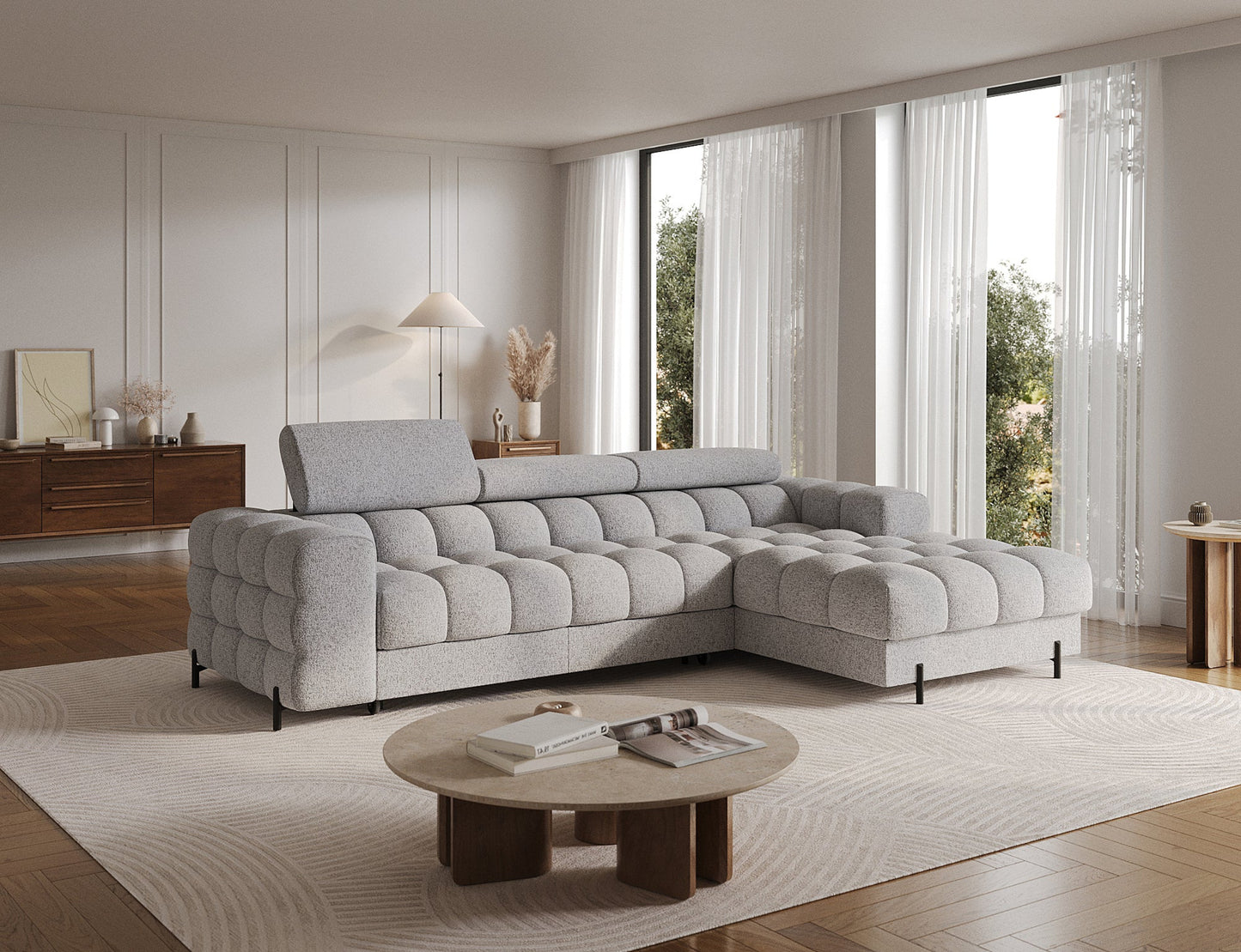 Narożnik Felro w tkaninie Pellerito 03 w jasnoszarej barwie, ustawiony na skos w aranżacji, elegancki design z funkcją spania i pojemnikiem na pościel, idealny do przestronnych wnętrz.
