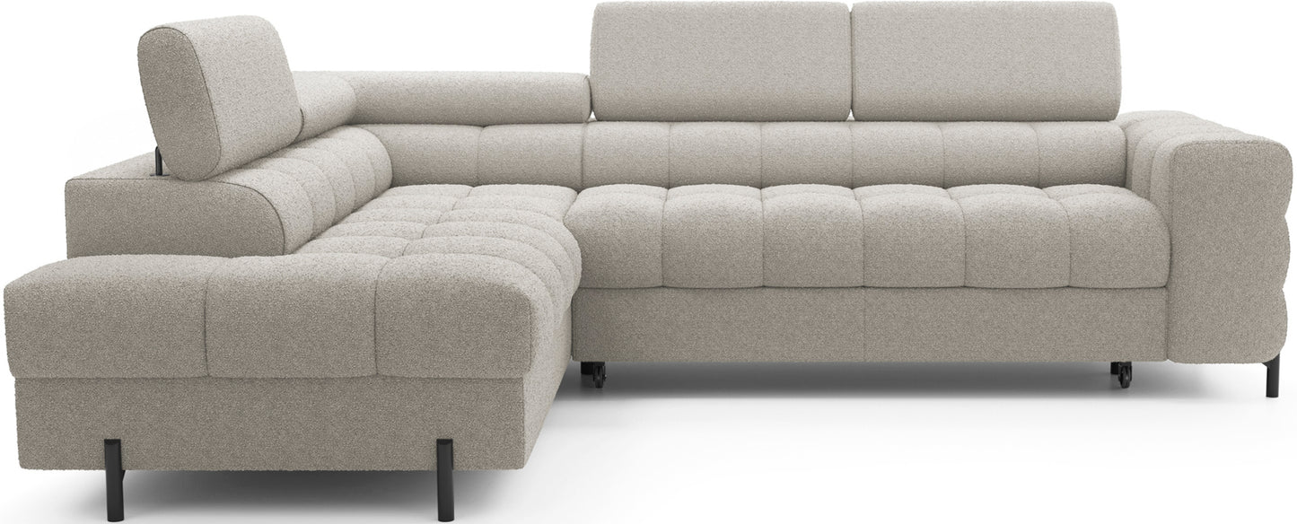 Narożnik Ferucce w kolorze Royal 20 beżowy, układ lewy – widok z przodu. Elegancka sofa narożna z pikowanymi poduchami siedziska i regulowanym zagłówkiem.