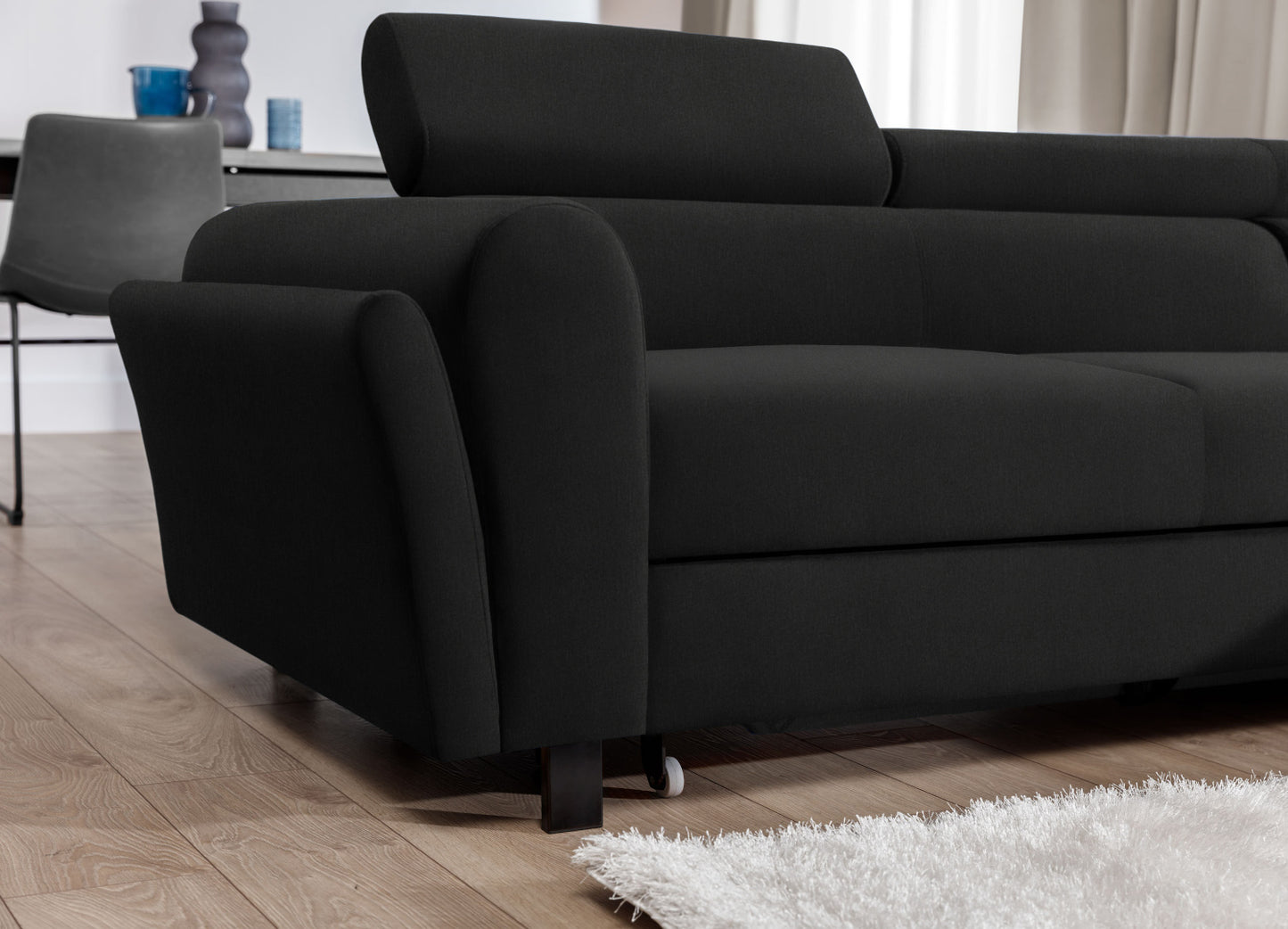 Nowoczesny narożnik Mariall w tkaninie Sawana 14 czarny z funkcją spania, sofa narożna rozłożona w jasnym salonie, wygodne miejsce do odpoczynku i snu, idealne rozwiązanie do małych mieszkań i dla gości