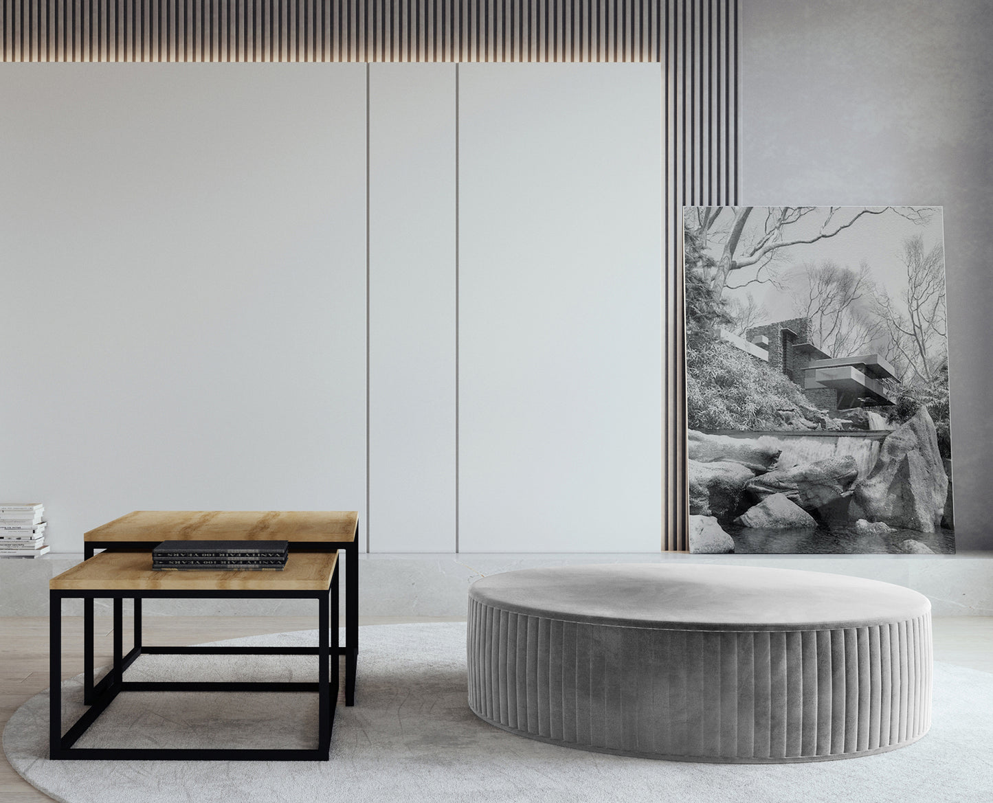 Pufa Lara w kolorze Monolith 84 jasnoszary, ustawiona w nowoczesnym salonie na jasnym dywanie, obok stolików kawowych z drewnianym blatem i czarną metalową podstawą.