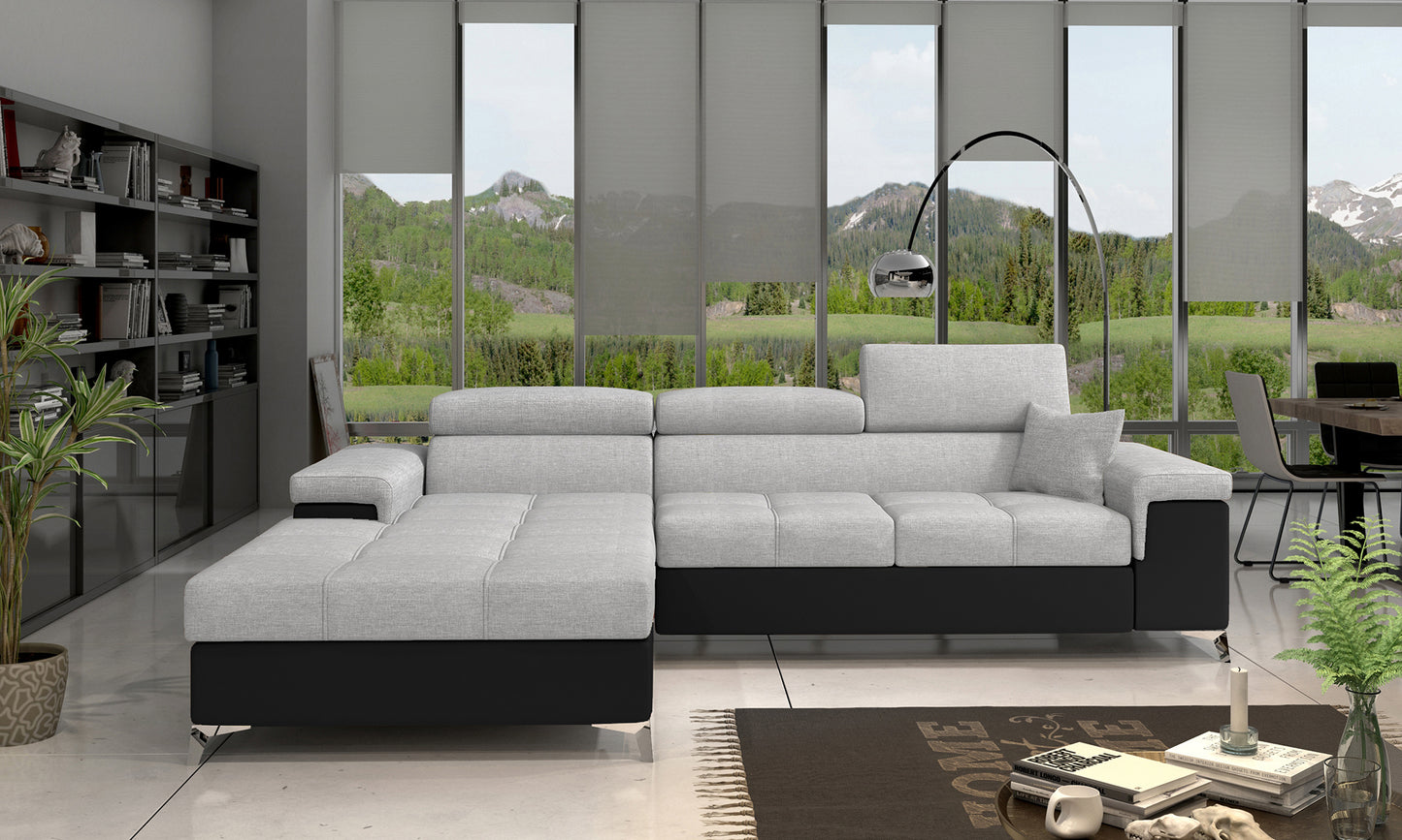 Narożnik Ricardo w układzie lewym, w kolorze Sawana 21 szary i Soft 11 czarny, ustawiony w nowoczesnym salonie na jasnym dywanie, obok stolika kawowego i regału z książkami.