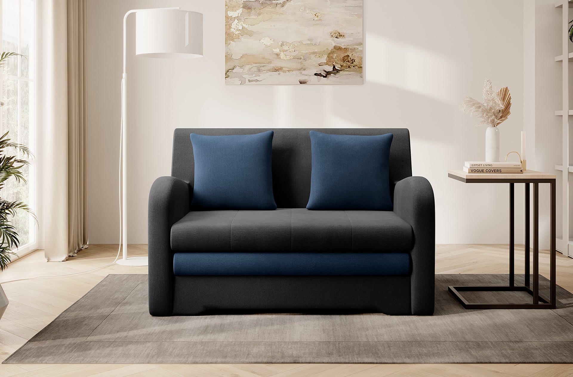 Dwukolorowa sofa Ario (grafit + granat), front; aranżacja salonu z lampą i stolikiem.