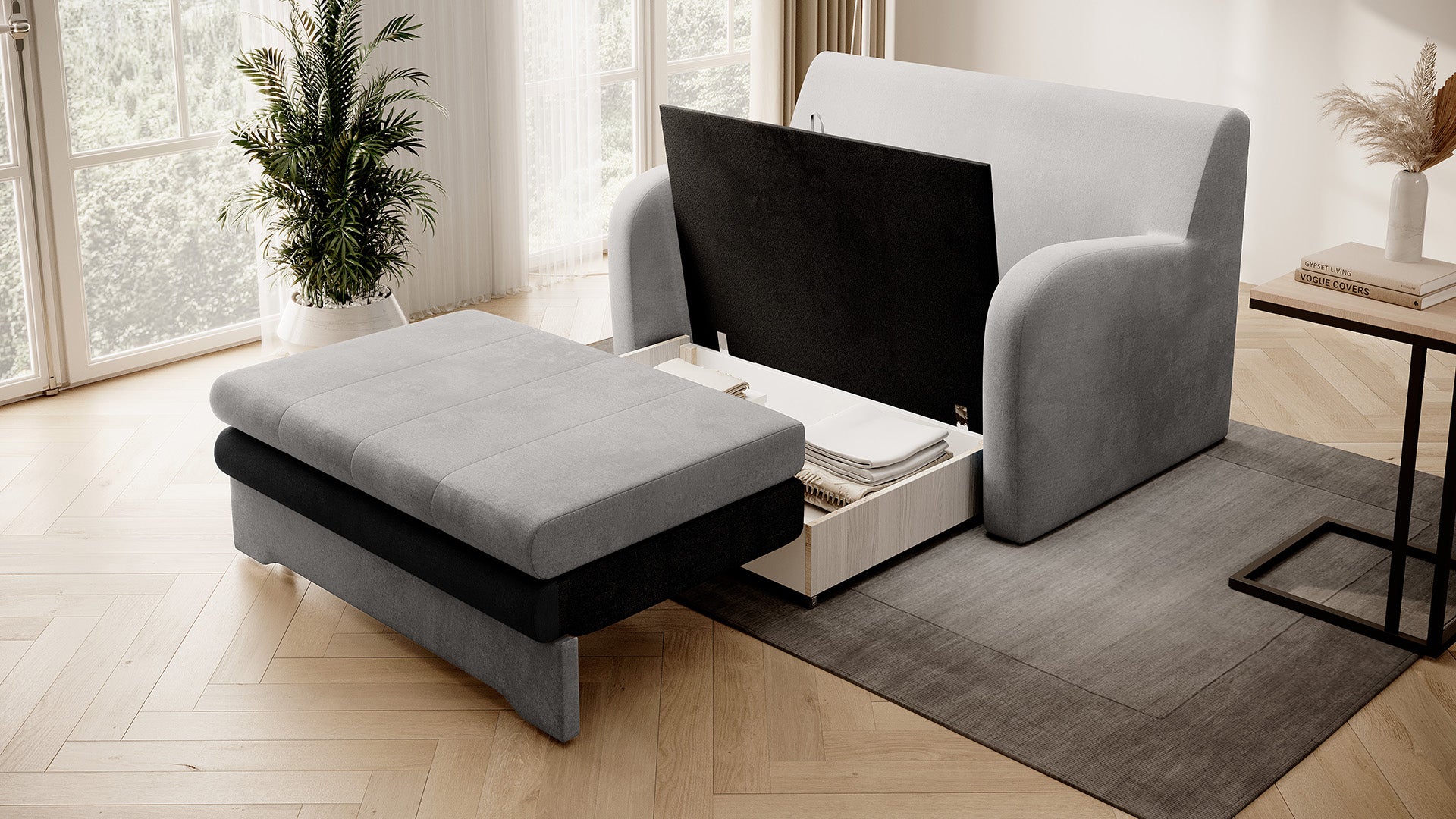 Dwukolorowa sofa Ario (jasnoszara + grafit) z otwartym pojemnikiem na pościel; ujęcie skośne.