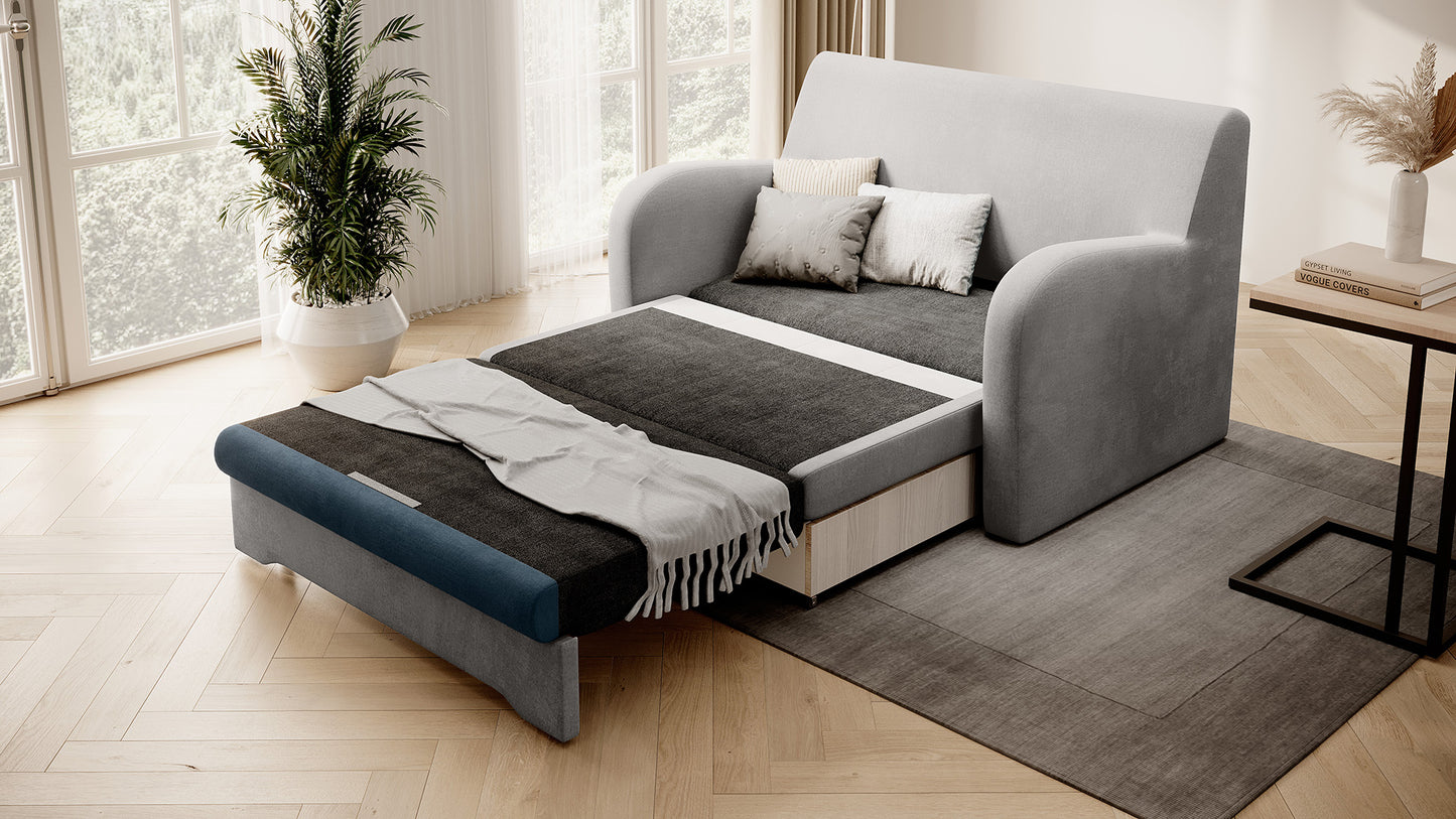 Sofa Ario dwukolorowa rozłożona do spania, ujęcie skośne w salonie przy oknie z rośliną.