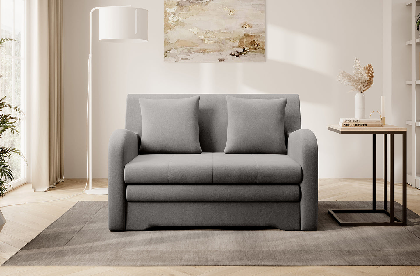 Szara sofa Ario, front; aranżacja salonu z lampą i stolikiem na dywanie.