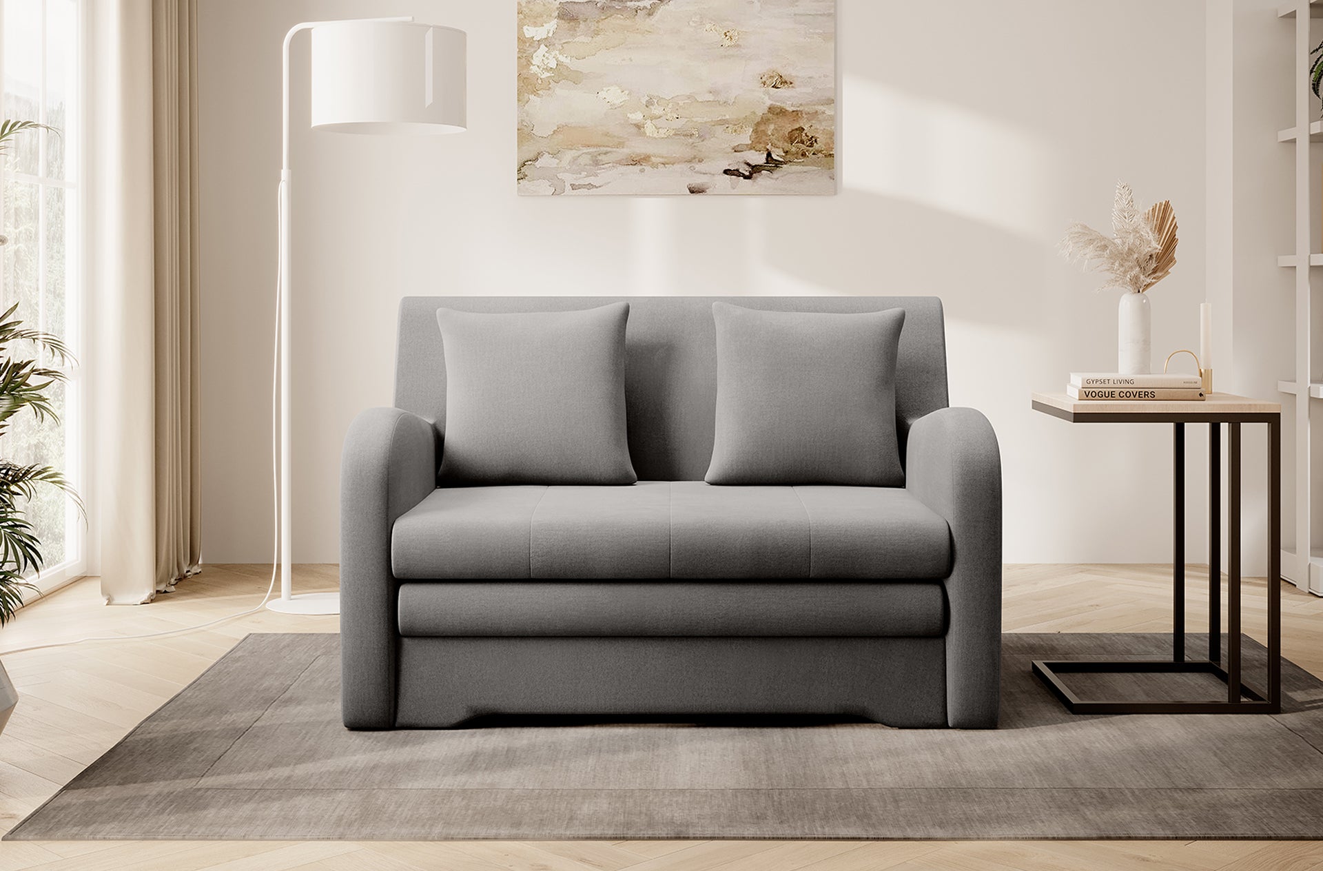 Szara sofa Ario, front; aranżacja salonu z lampą i stolikiem na dywanie.