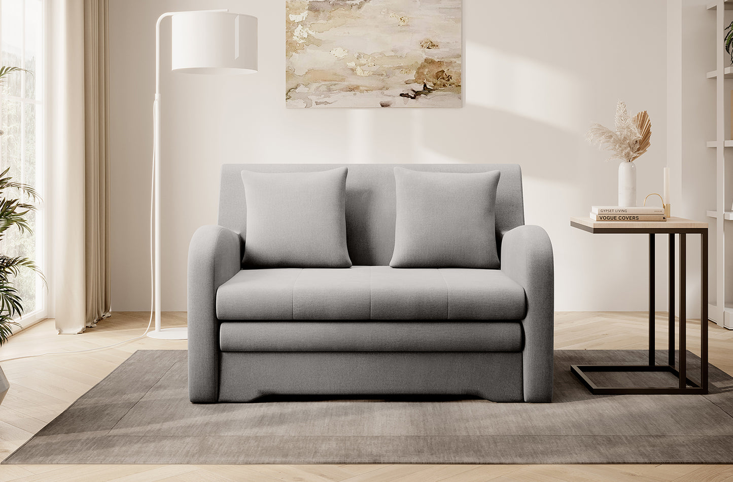 Szara sofa Ario, front; aranżacja salonu z lampą i stolikiem na dywanie.