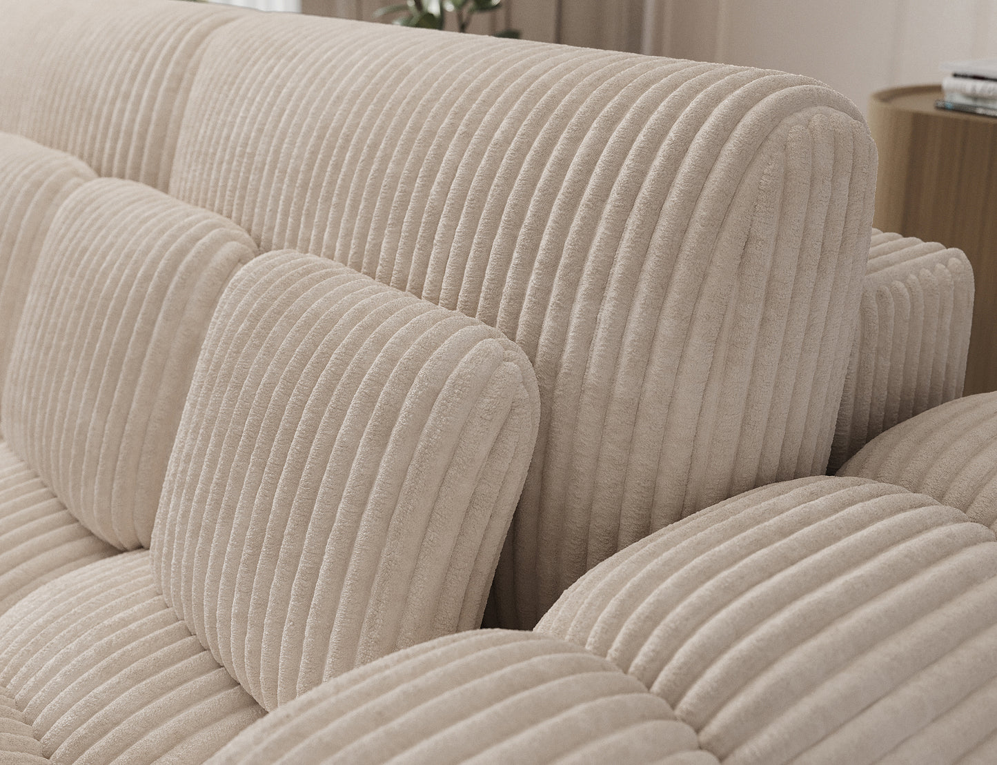 Miękki sztruksowy materiał i geometryczne przeszycia poduszek – detal sofy Cotonn Modullo w eleganckim, kremowym odcieniu.