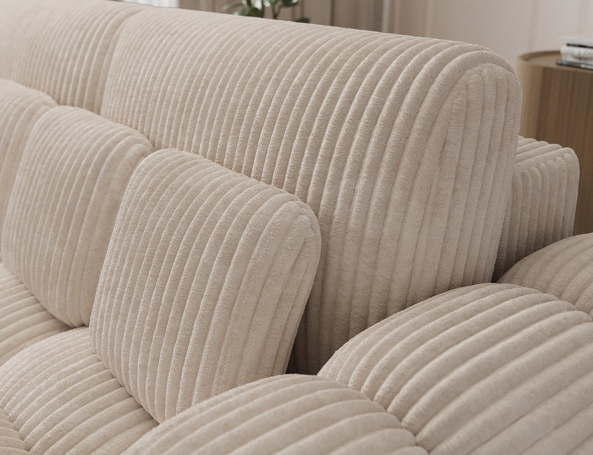 Miękki sztruksowy materiał i geometryczne przeszycia poduszek – detal sofy Cotonn Modullo w eleganckim, kremowym odcieniu.
