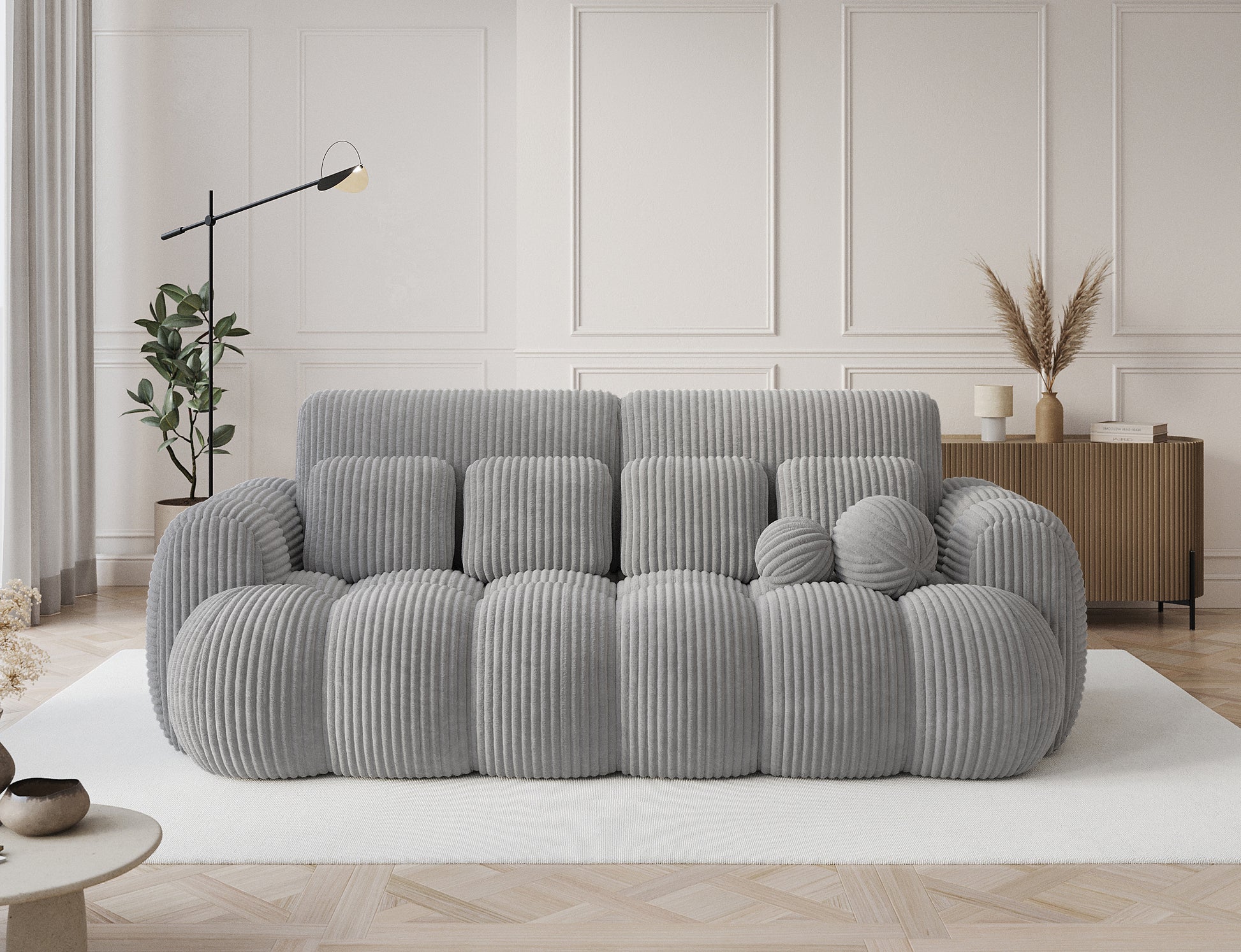 Cotonn Modullo – jasnoszara sofa z welurowego sztruksu, z miękkimi poduchami i kulami. Styl i komfort w jednym.