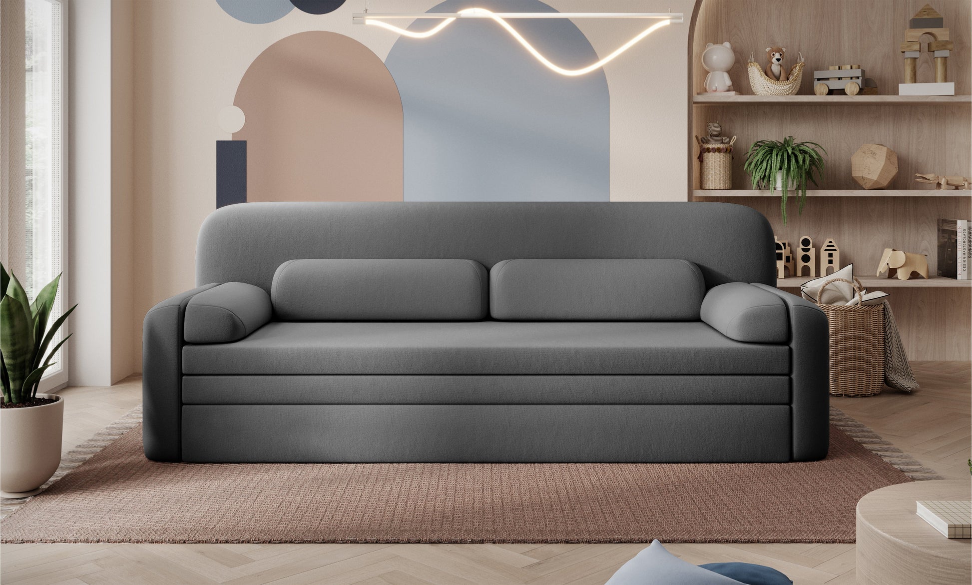 Sofa Elioss Sola 06 w kolorze szarym na tle dekoracyjnej ściany – nowoczesna forma, gładka tapicerka, jasne i przytulne wnętrze.