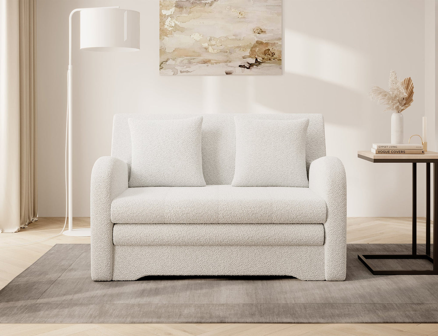 Biała sofa Jarell w tkaninie bouclé, front, dwie poduszki; aranżacja salonu z lampą i stolikiem na dywanie.