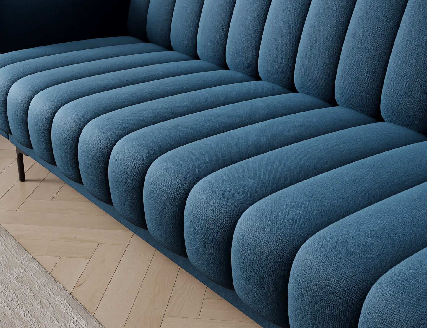 Siedzisko sofy Roneyy w tkaninie Lukso 40 – głębokie, pionowe przeszycia w miękkim, granatowym welurze tworzące dynamiczną fakturę.