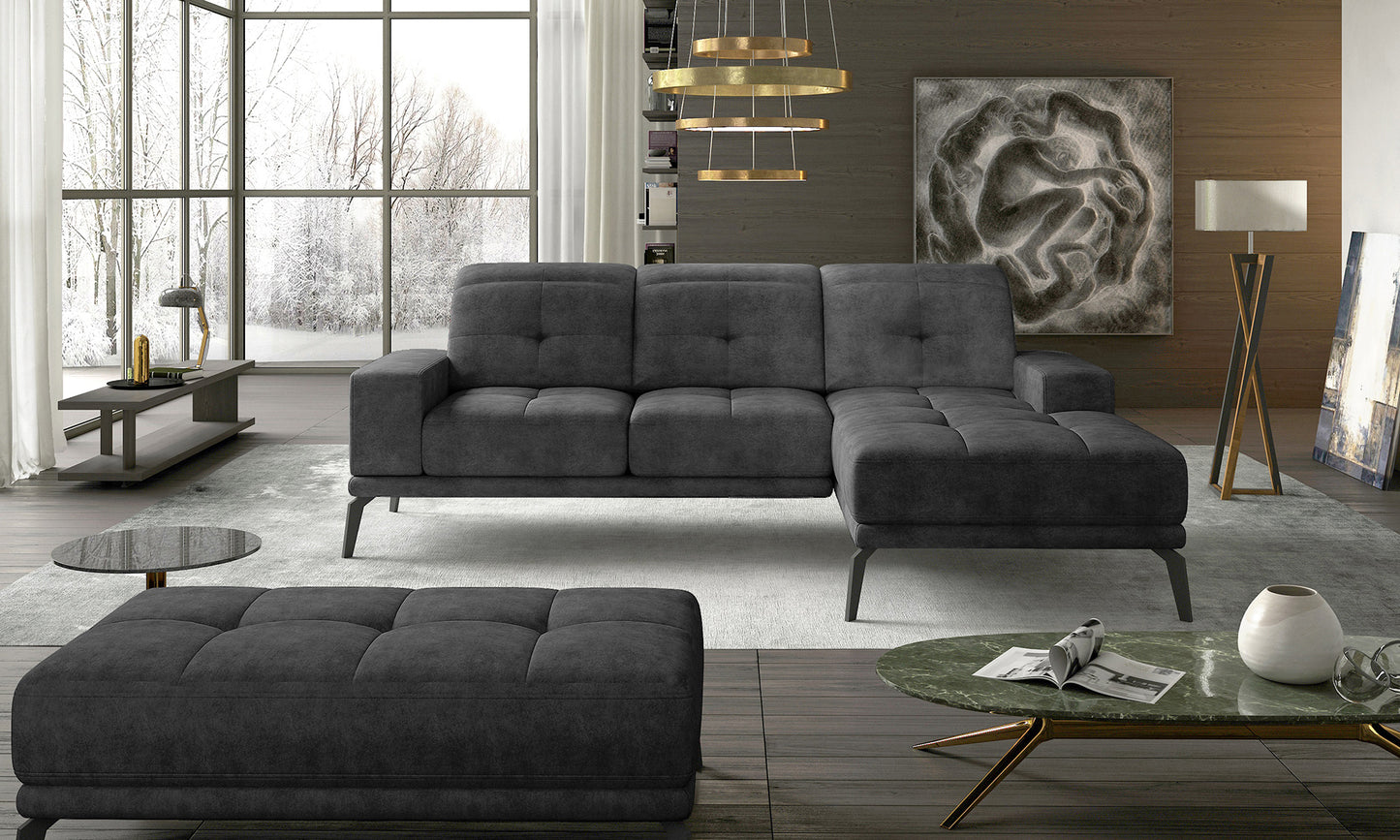 Designerski narożnik w ciemnoszarej tkaninie Dora 95 z wygodnymi poduszkami oparciowymi oraz nowoczesną linią. Duży narożnik wypoczynkowy do salonu tworzący funkcjonalną i elegancką strefę codziennego odpoczynku.