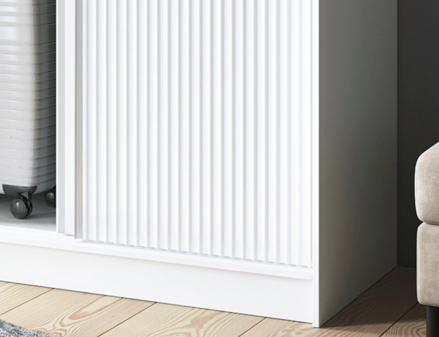 Szczegół szafy Biancco II w kolorze białym, eleganckie wykończenie frontu z pionowymi frezowaniami.