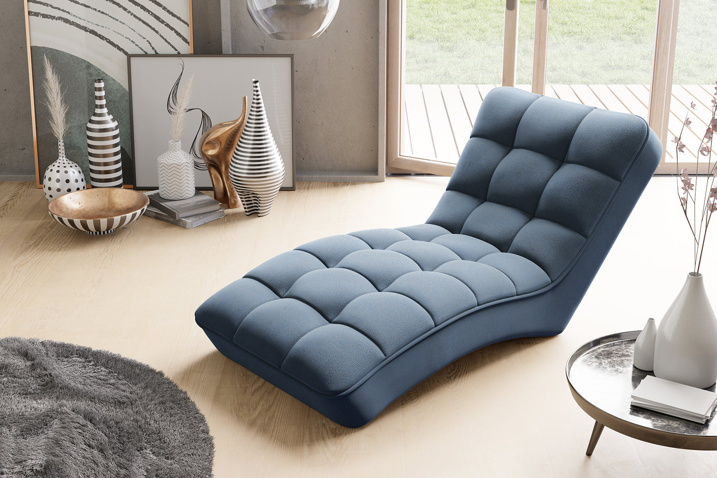 Szezlong Loren w kolorze Gojo 40 niebieski ustawiony w jasnym wnętrzu z dostępem do tarasu, otoczony designerskimi wazonami i miękkim dywanem.