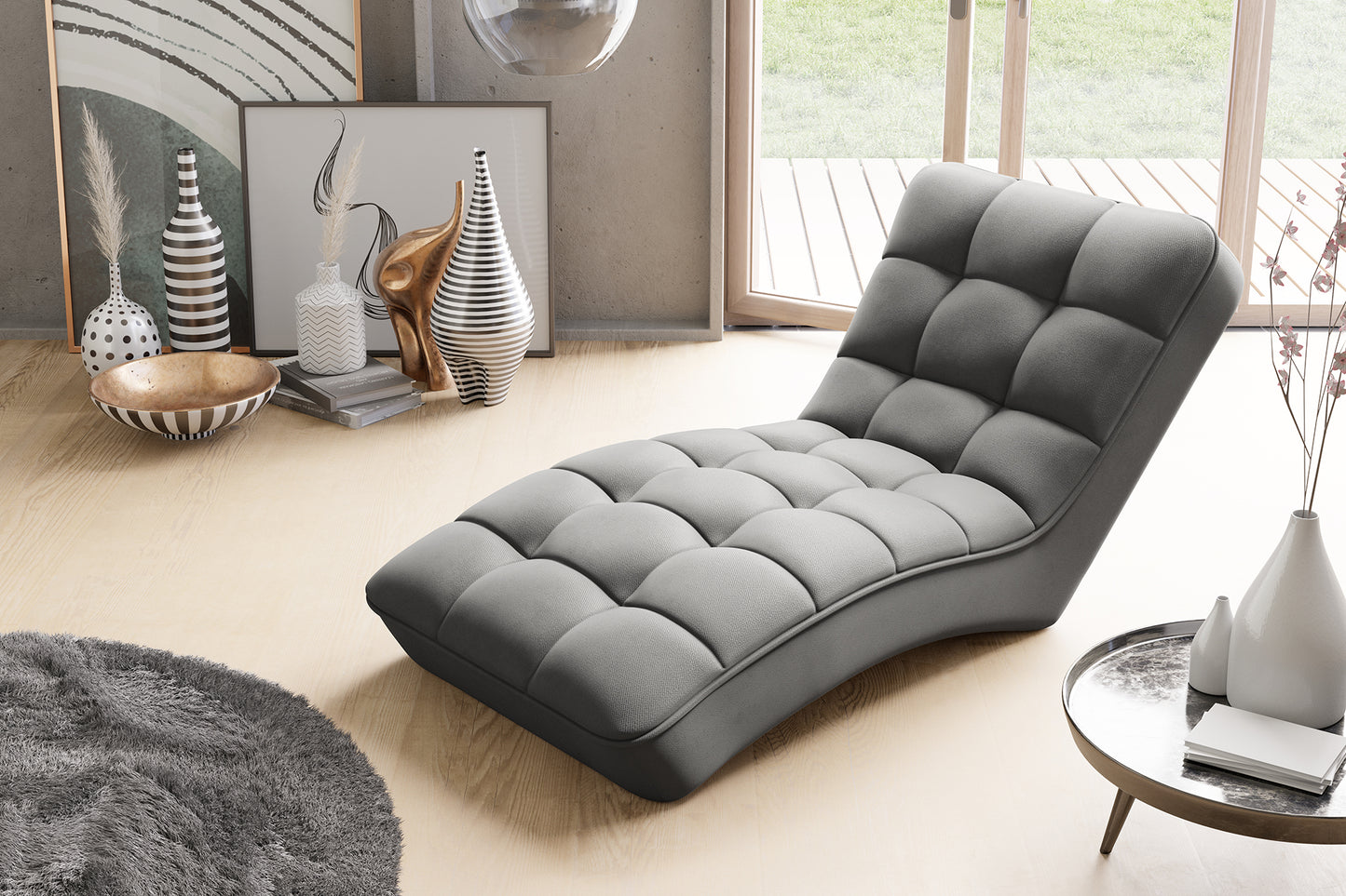 Szezlong Loren w szarym kolorze Sola 06 w jasnym wnętrzu z drewnianą podłogą i oknami tarasowymi, w otoczeniu designerskich dodatków.